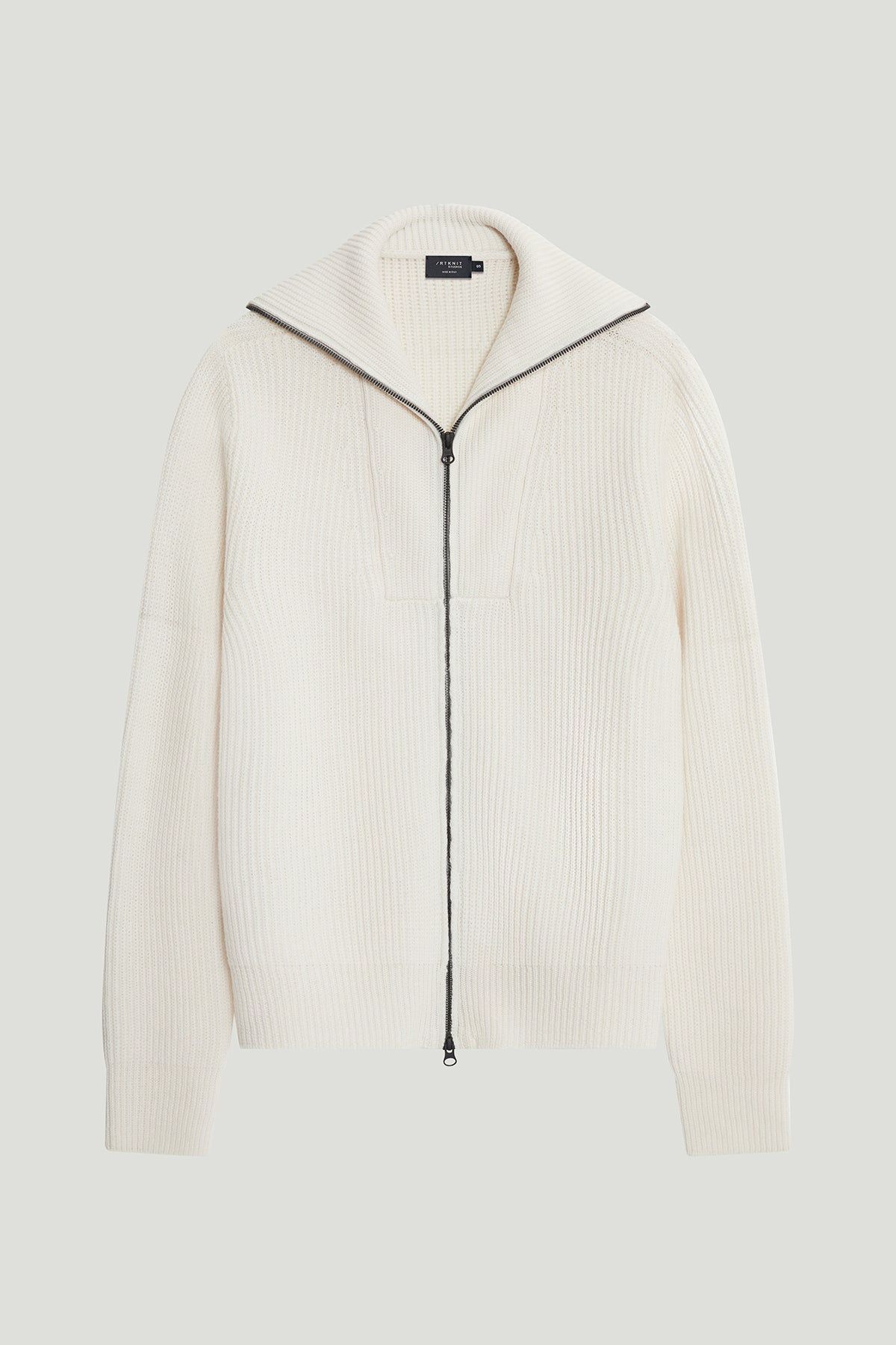 White ribbed sweater with a zipper on a light gray background