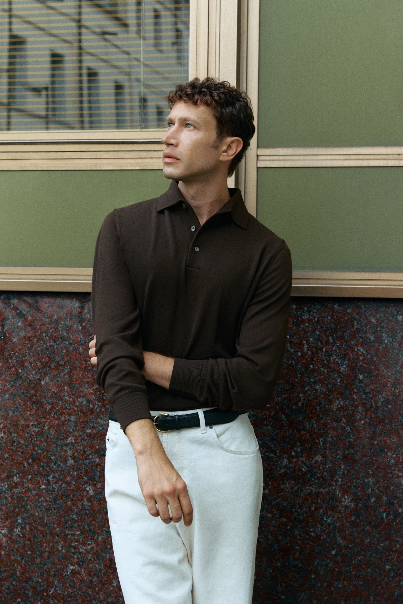 Man wearing a brown long-sleeve polo shirt on city background