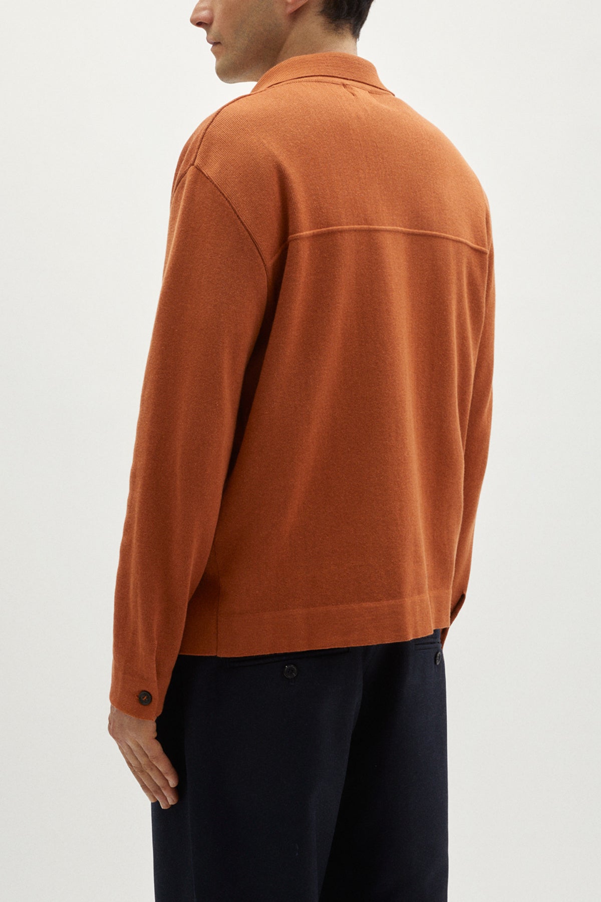 Person wearing an orange jacket on a white background