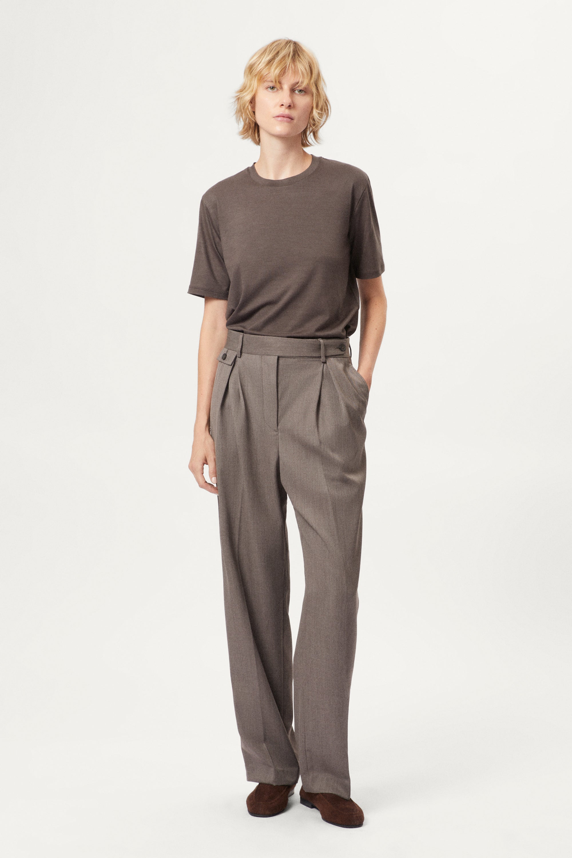 Person wearing a brown active wool t-shirt and pants on a white background