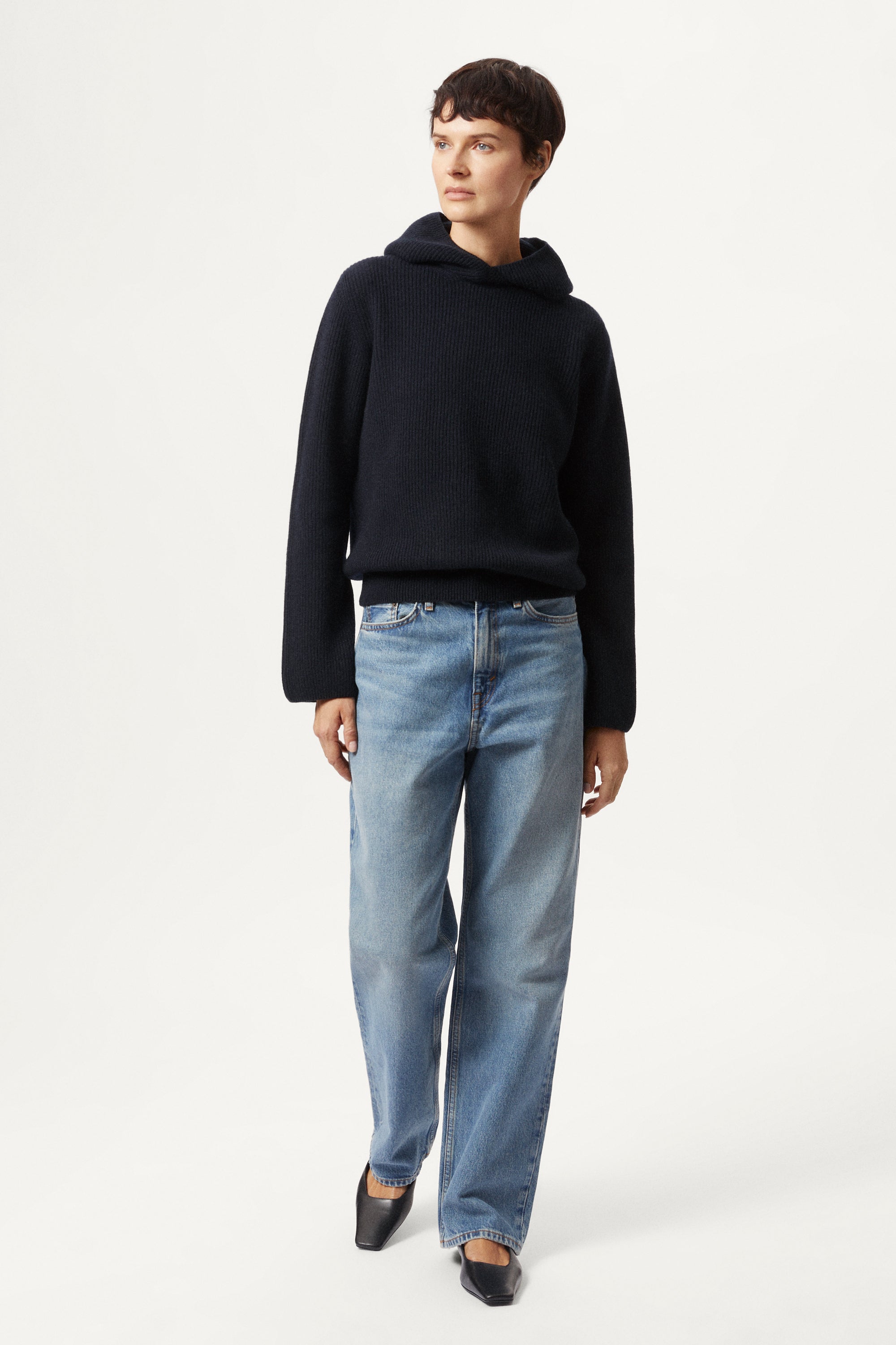 Person wearing a blue navy Woolen Ribbed Hoodie and blue jeans on a white background