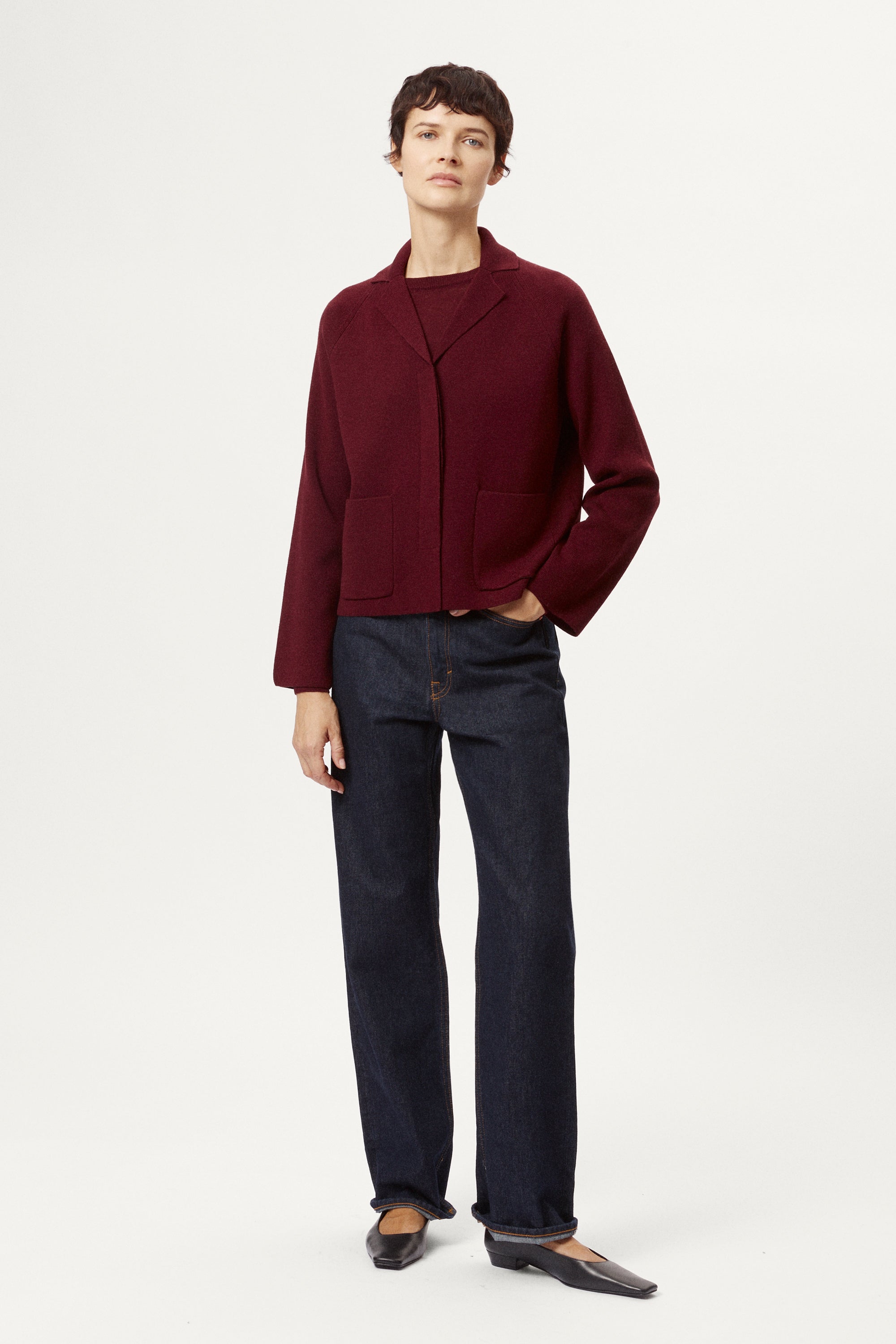 Woman wearing a burgundy jacket on a white background