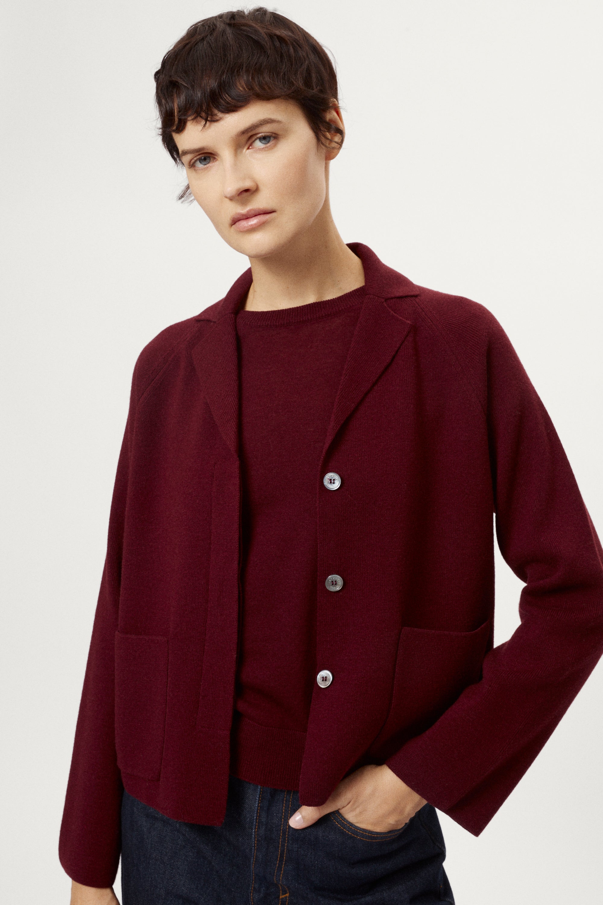 Woman wearing a burgundy jacket on a white background