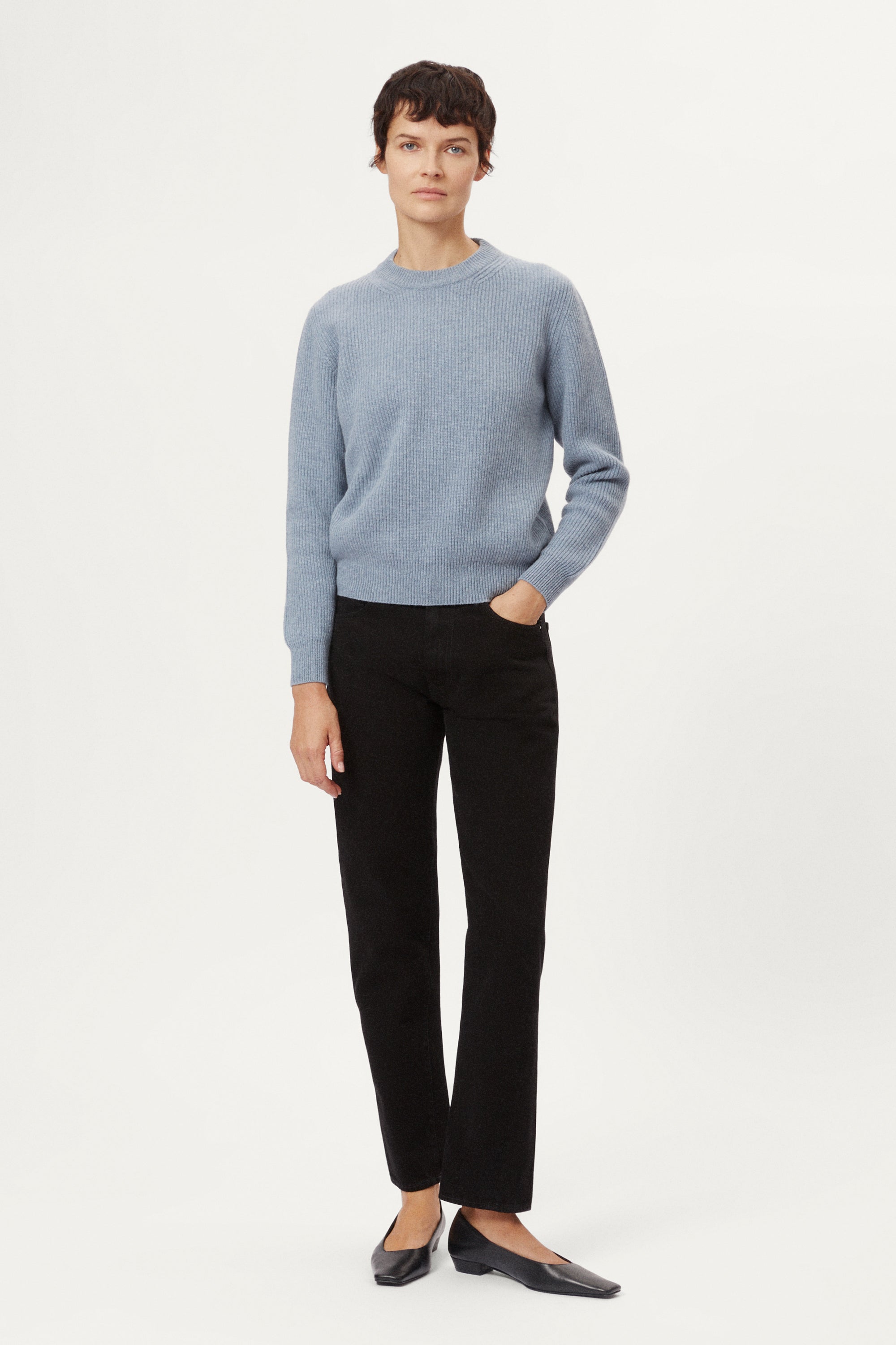 Woman wearing a wool light blue sweater on a white background