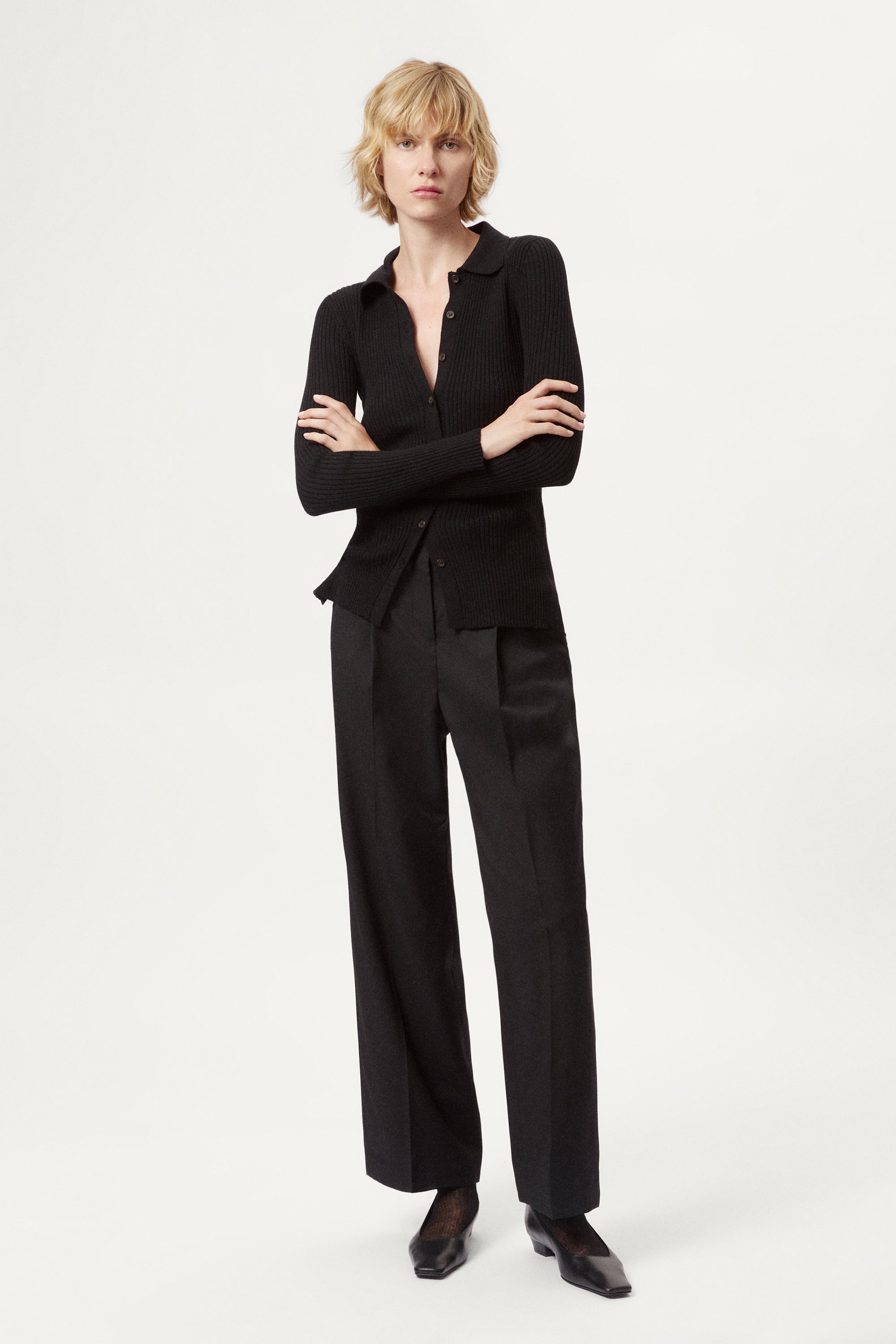 Woman wearing a black ribbed merino shirt on a white background