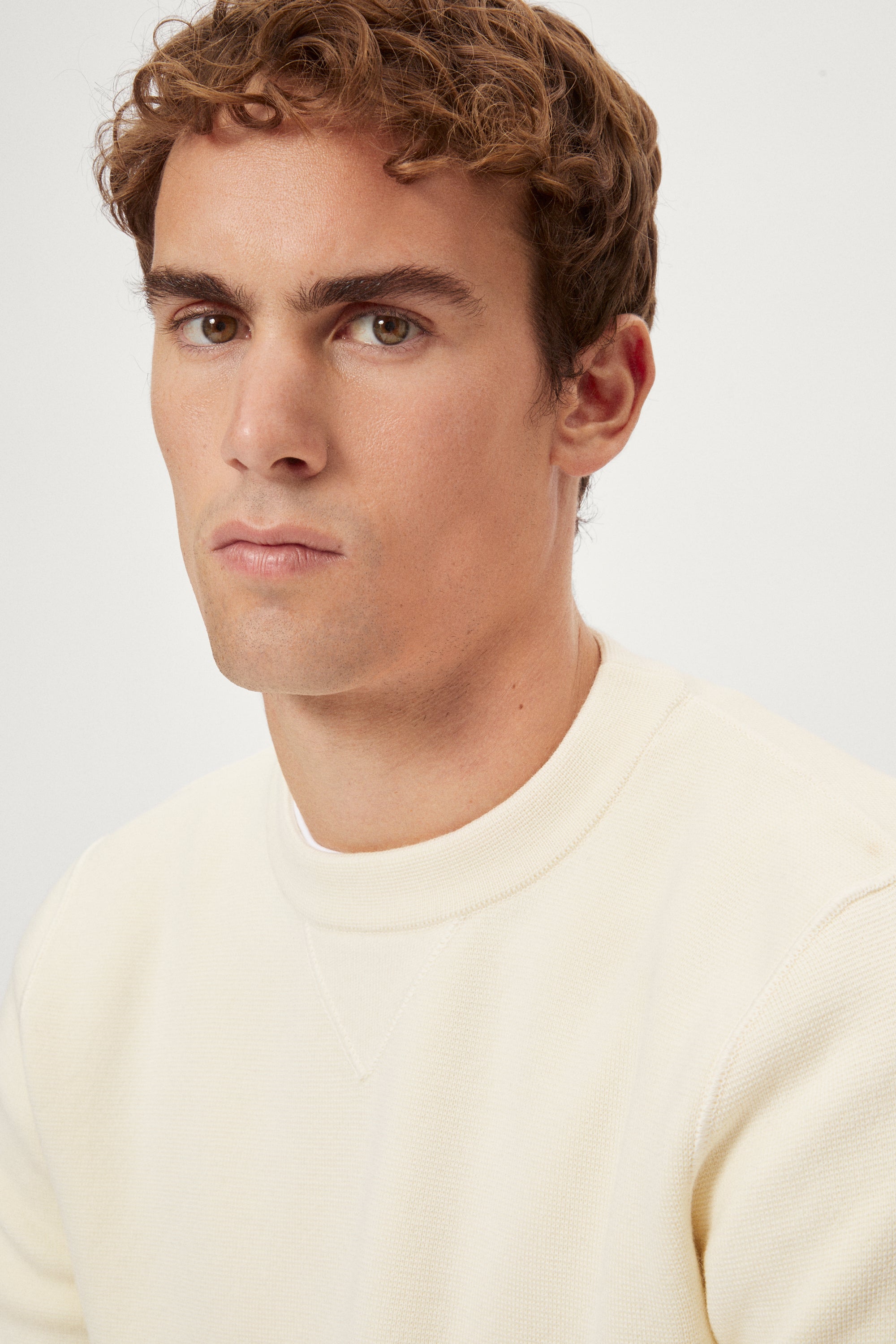 Man wearing a white Merino Wool Sweatshirt