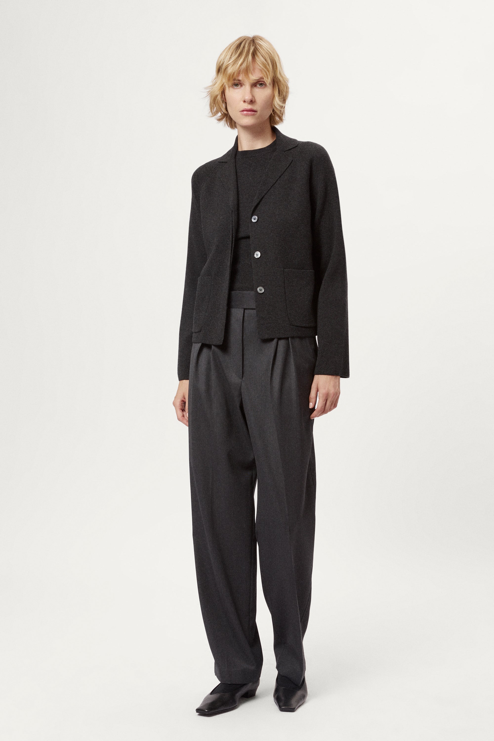 Woman wearing a grey Wool Rever Jacket on a white background