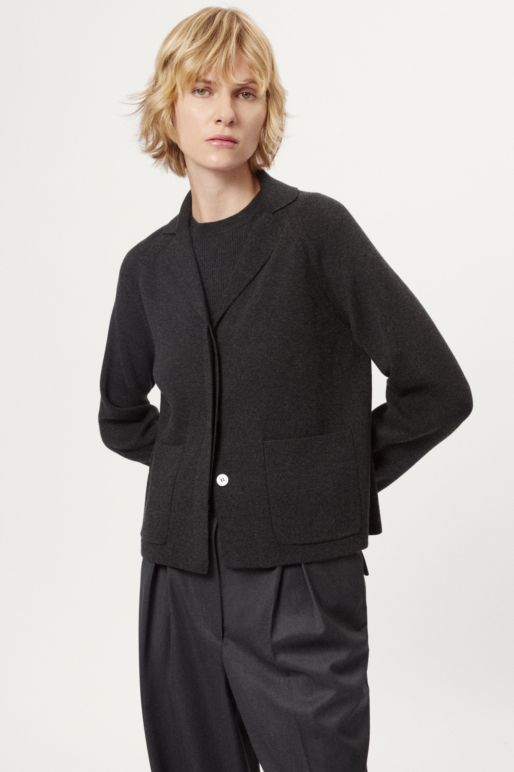 Woman wearing a grey Wool Rever Jacket on a white background