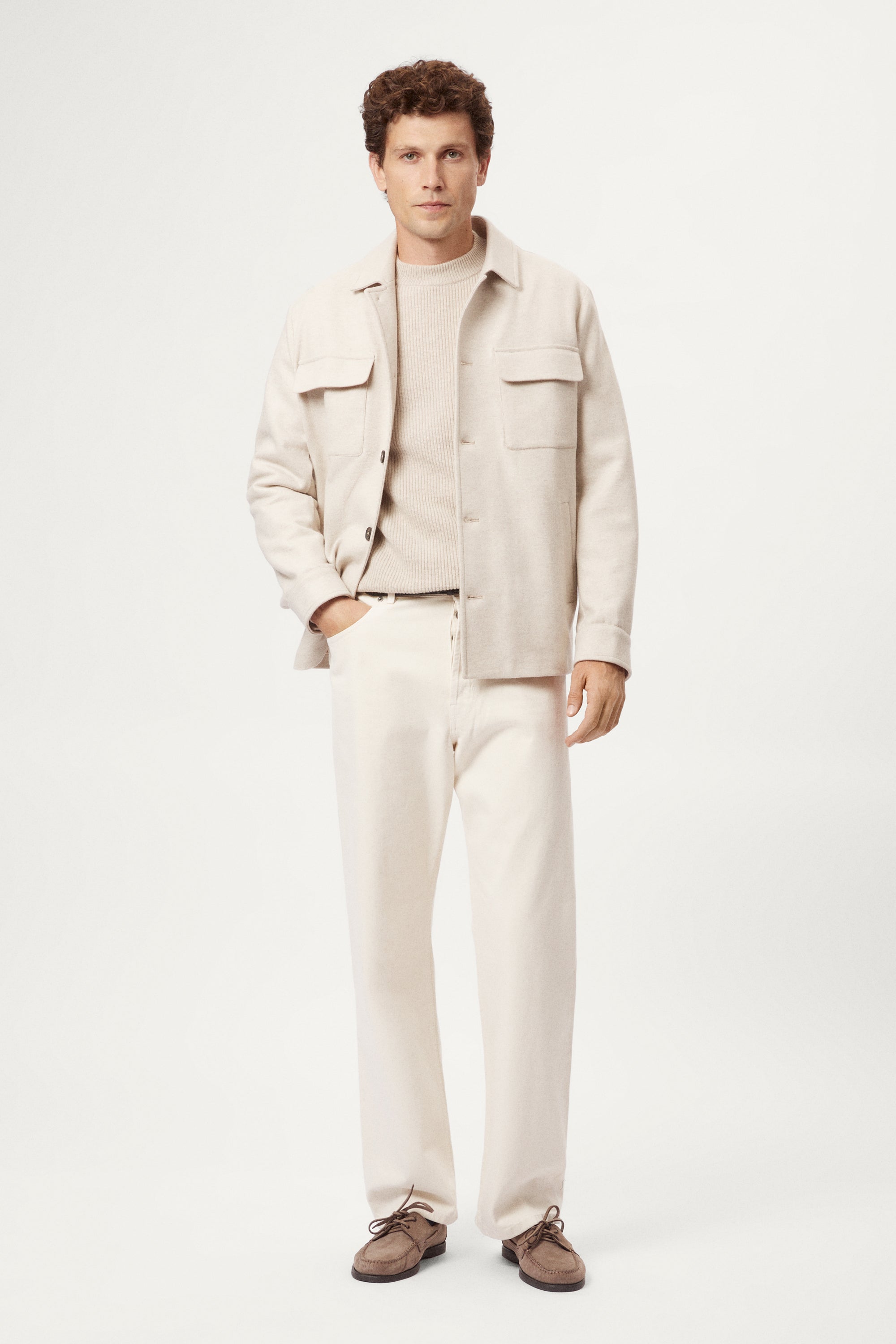 Man wearing a woolen ecru jacket with button details on a white background