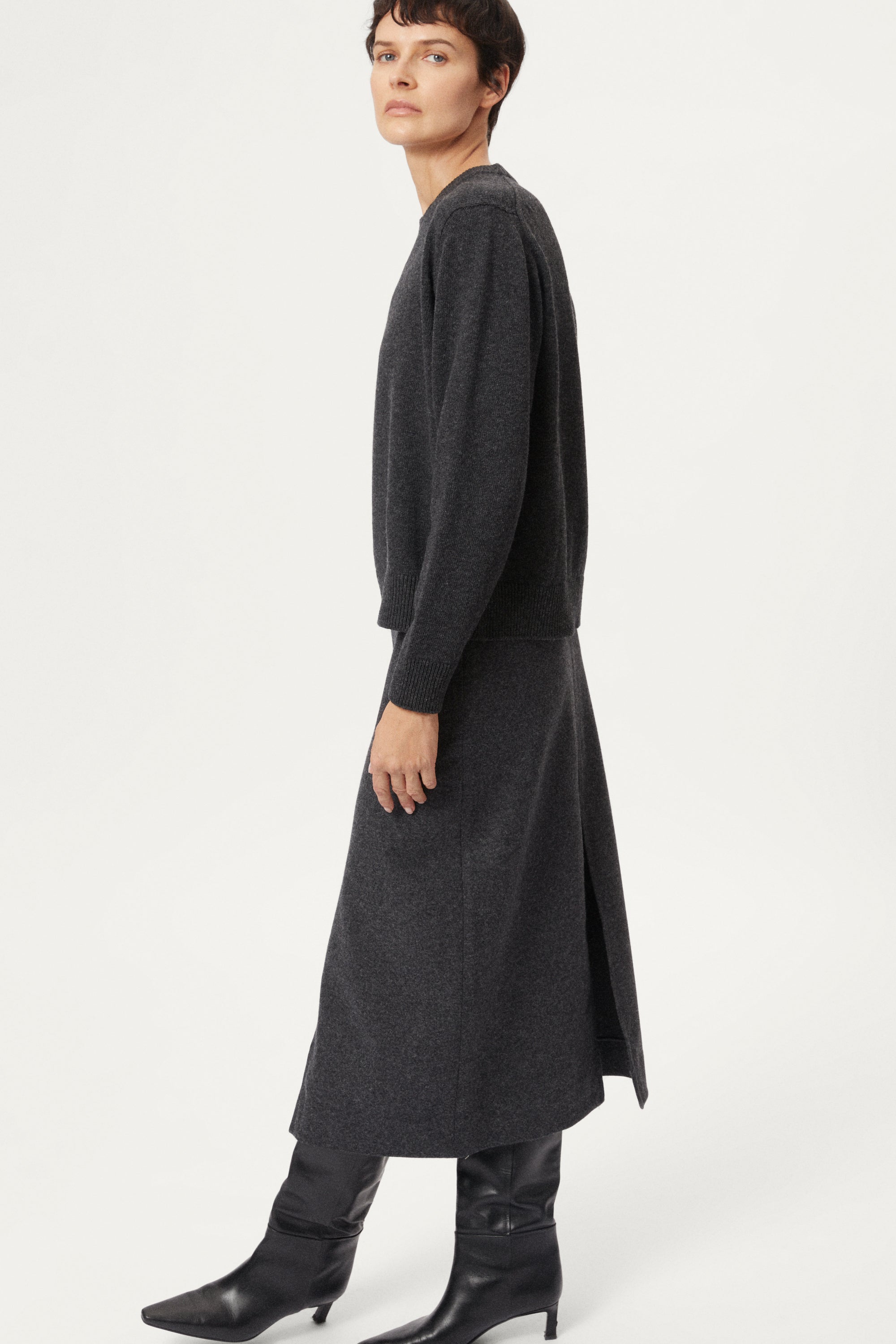 woman wearing a dark gray Woolen Plain Stitch Sweaterr on a light gray background