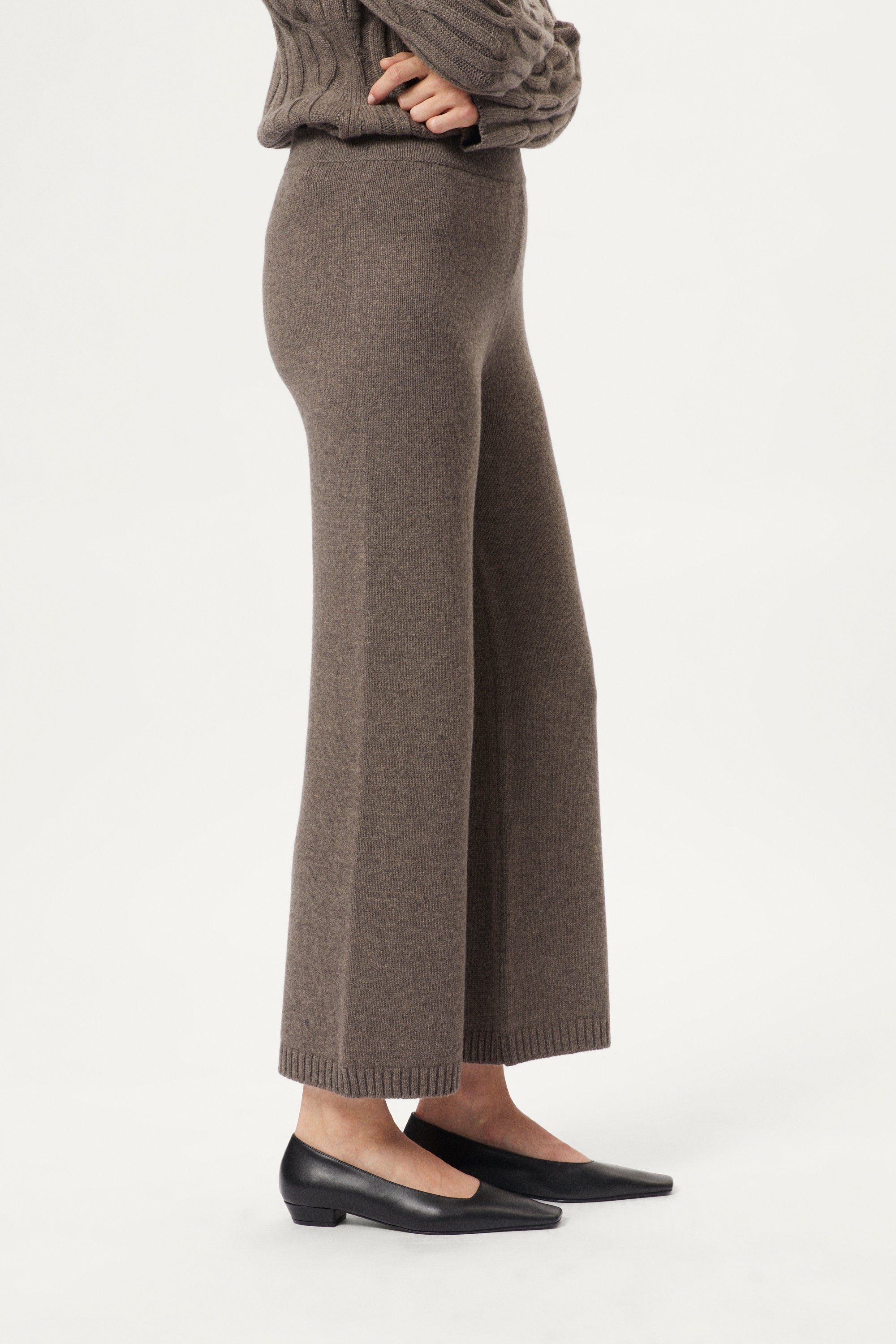 taupe woolen knitted pants worn by a person on a white background