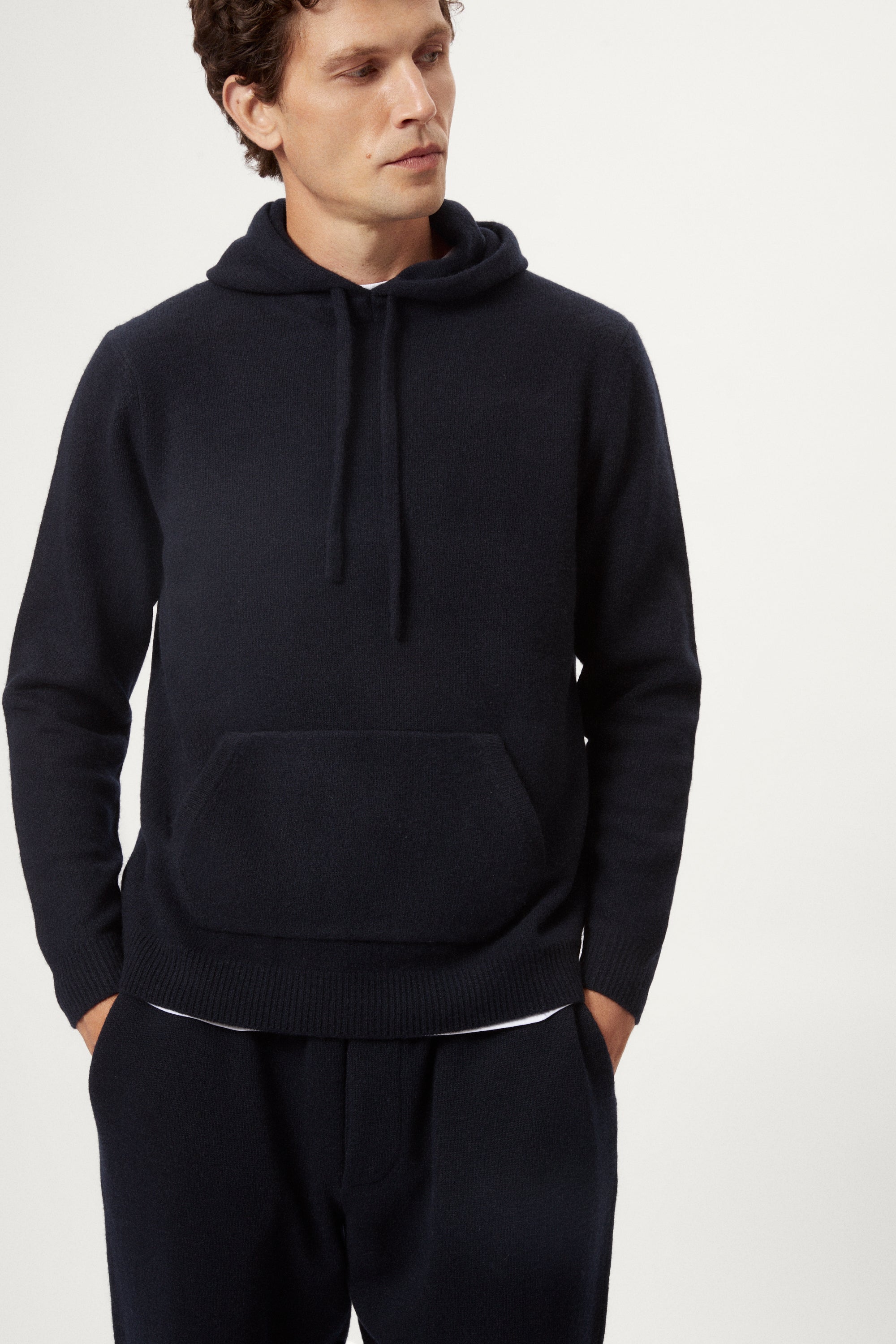 Man wearing a blue navy woolen hoodie and pants on a white background