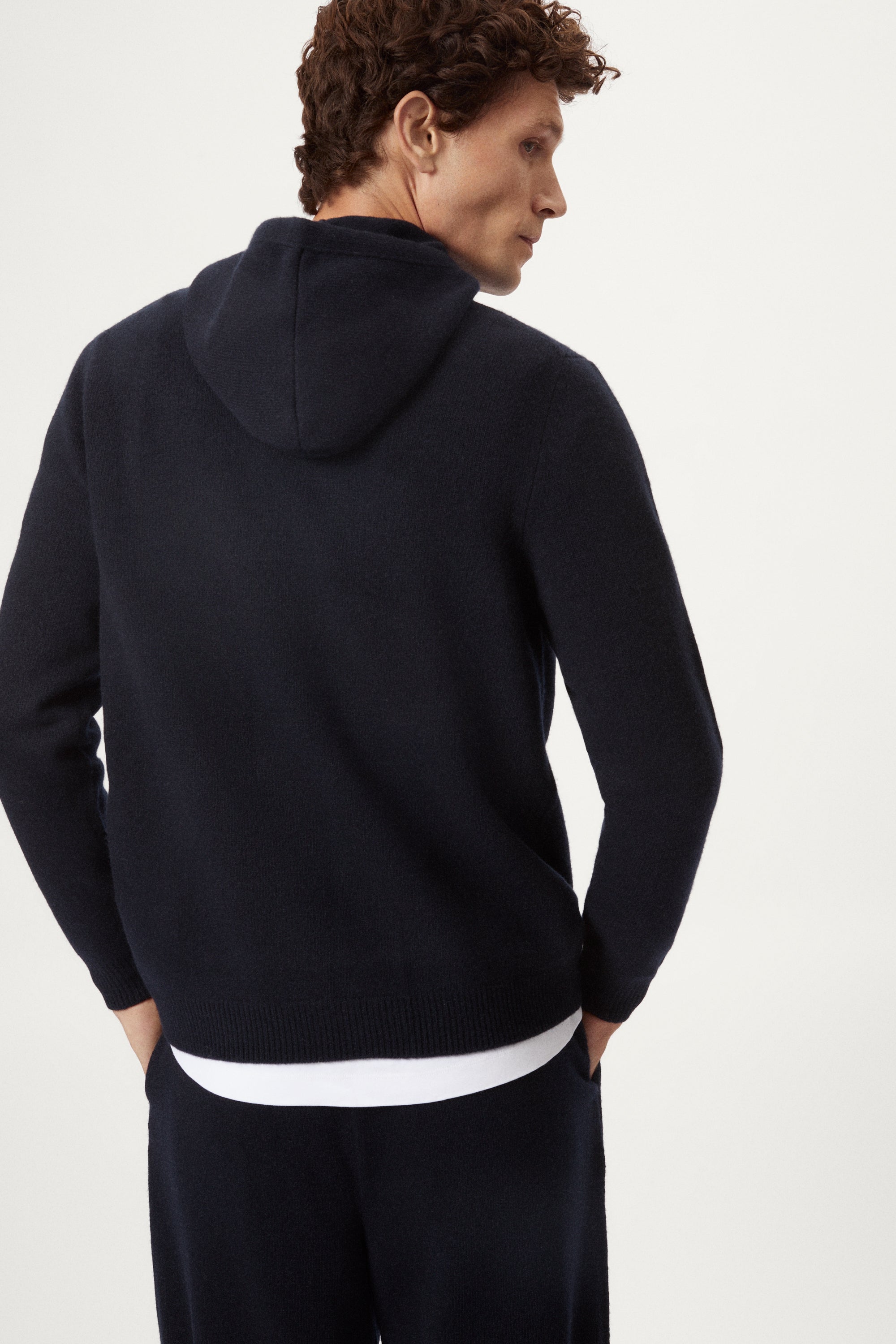 Man wearing a blue navy woolen hoodie and pants on a white background