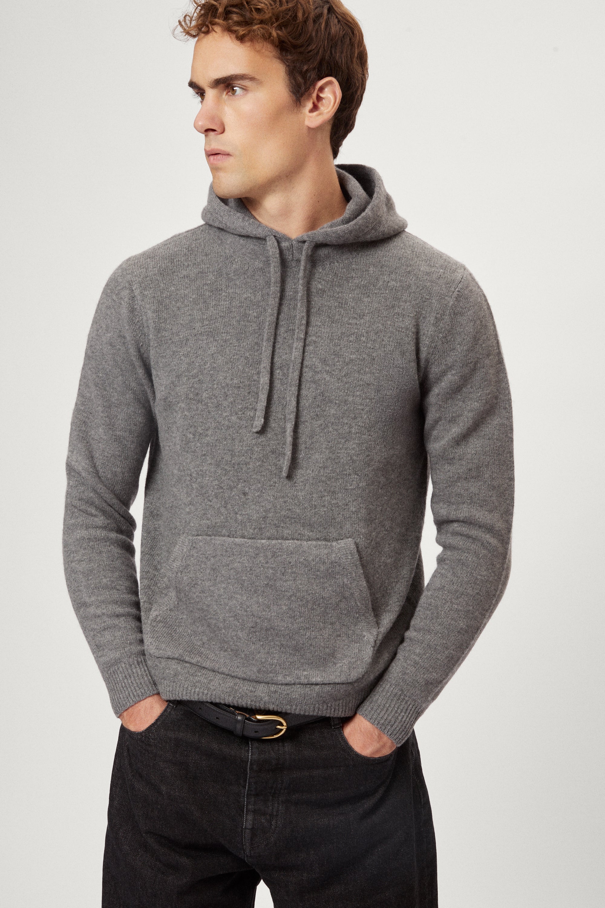 Man wearing a light gray woolen hoodie on a white background