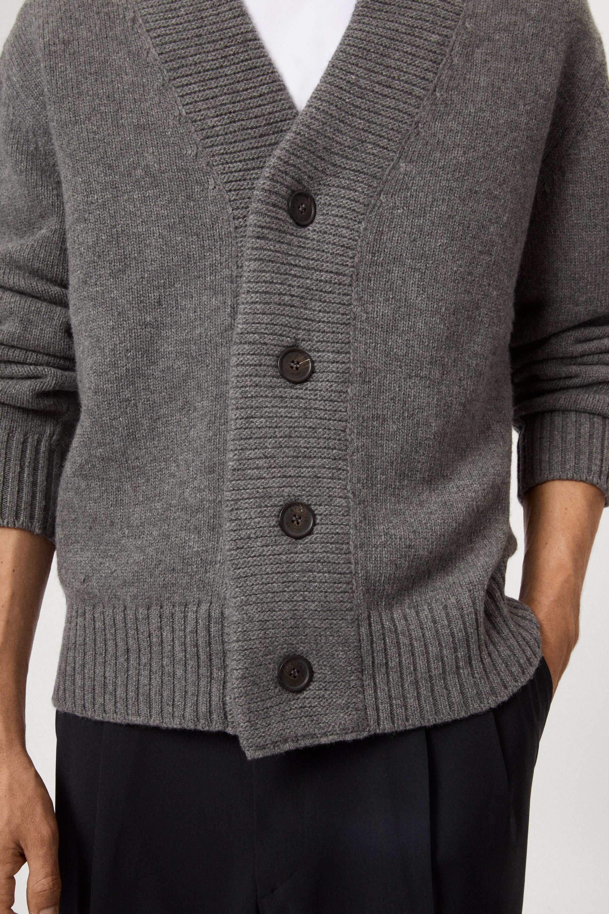 Man wearing a light gray Woolen Boxy Cardigan over a white shirt on a light gray background