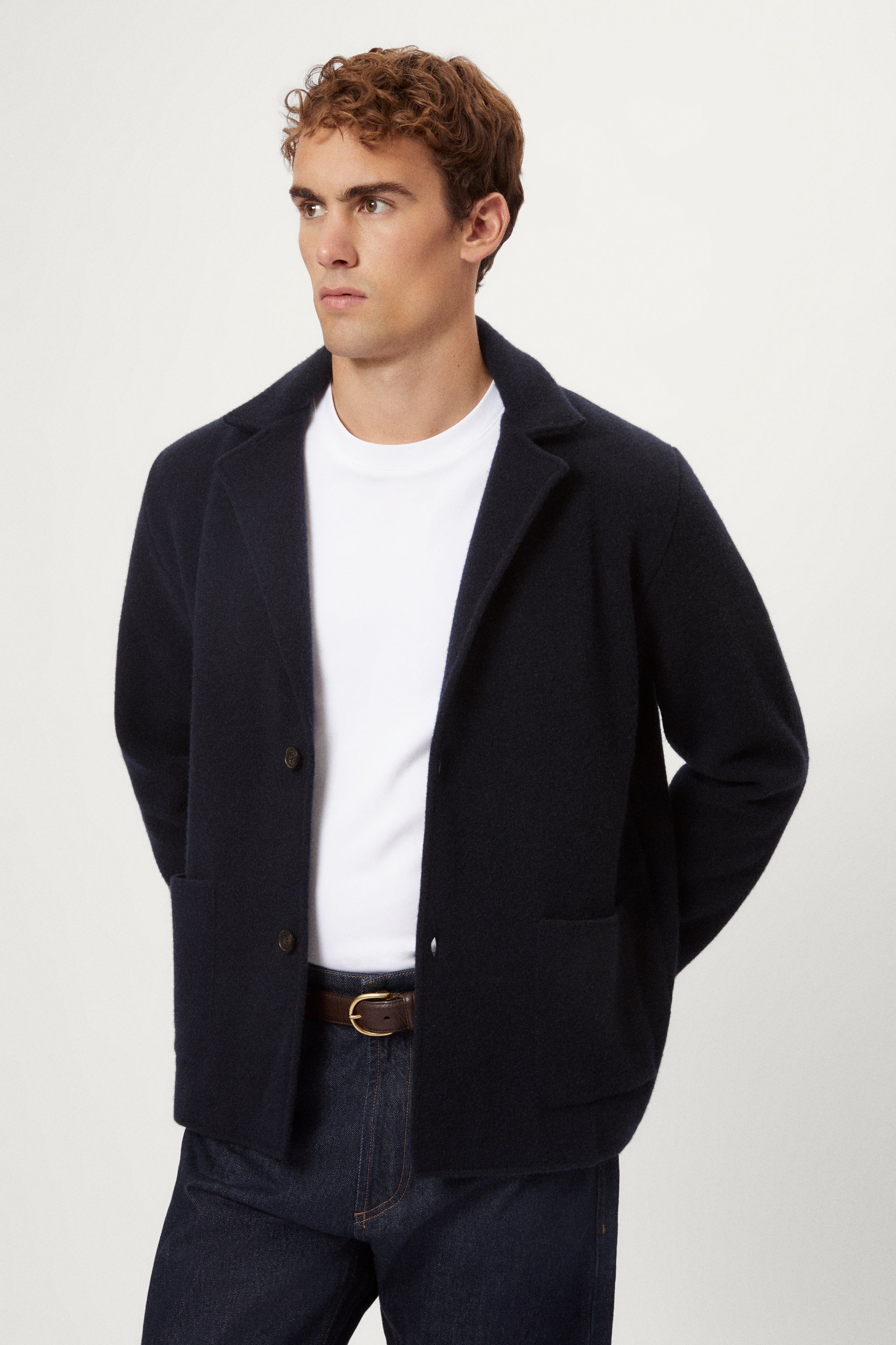 Man wearing a blue Boiled Wool Blazer, white shirt, and dark jeans on a white background