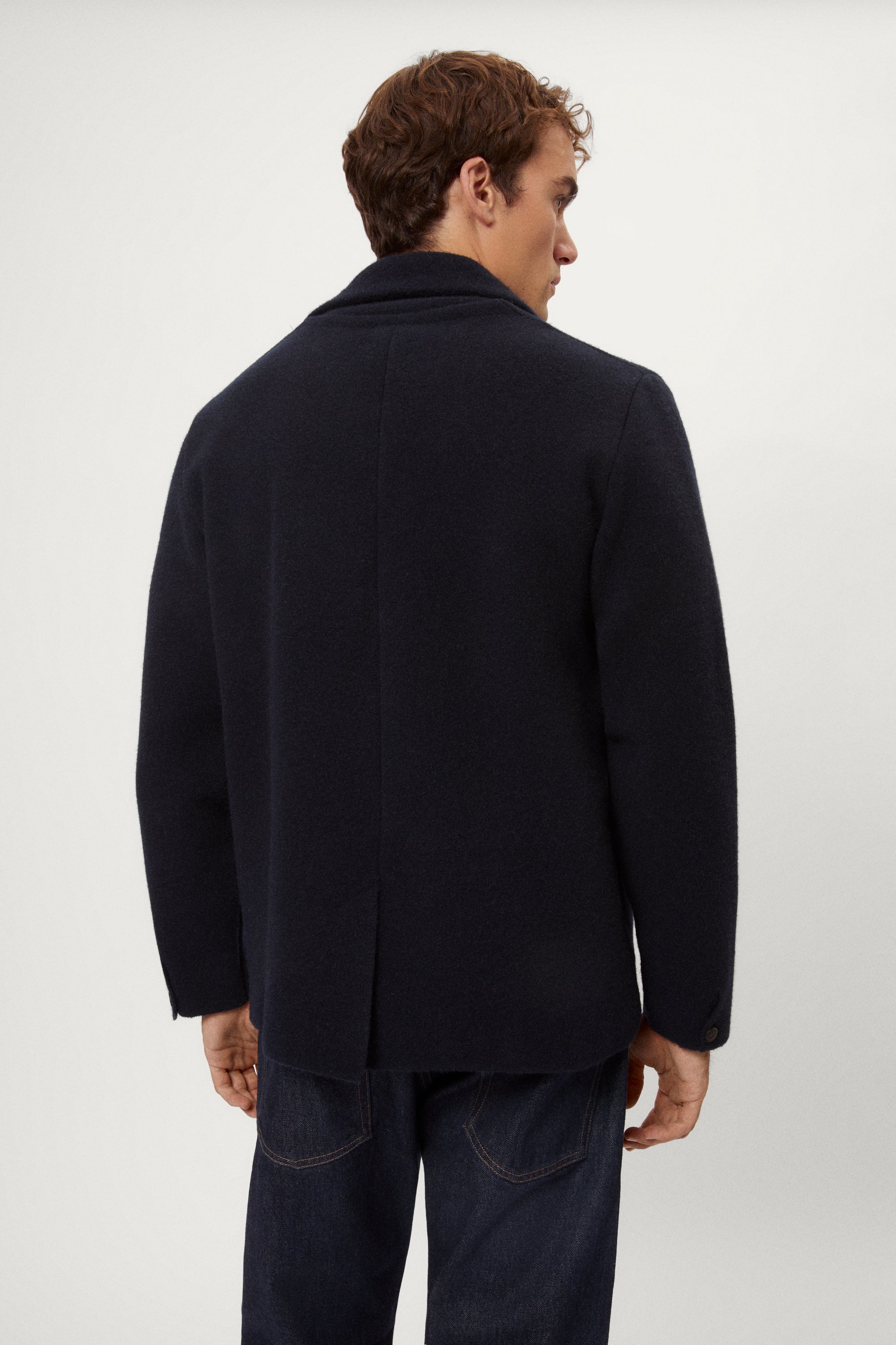 Man wearing a blue Boiled Wool Blazer, white shirt, and dark jeans on a white background