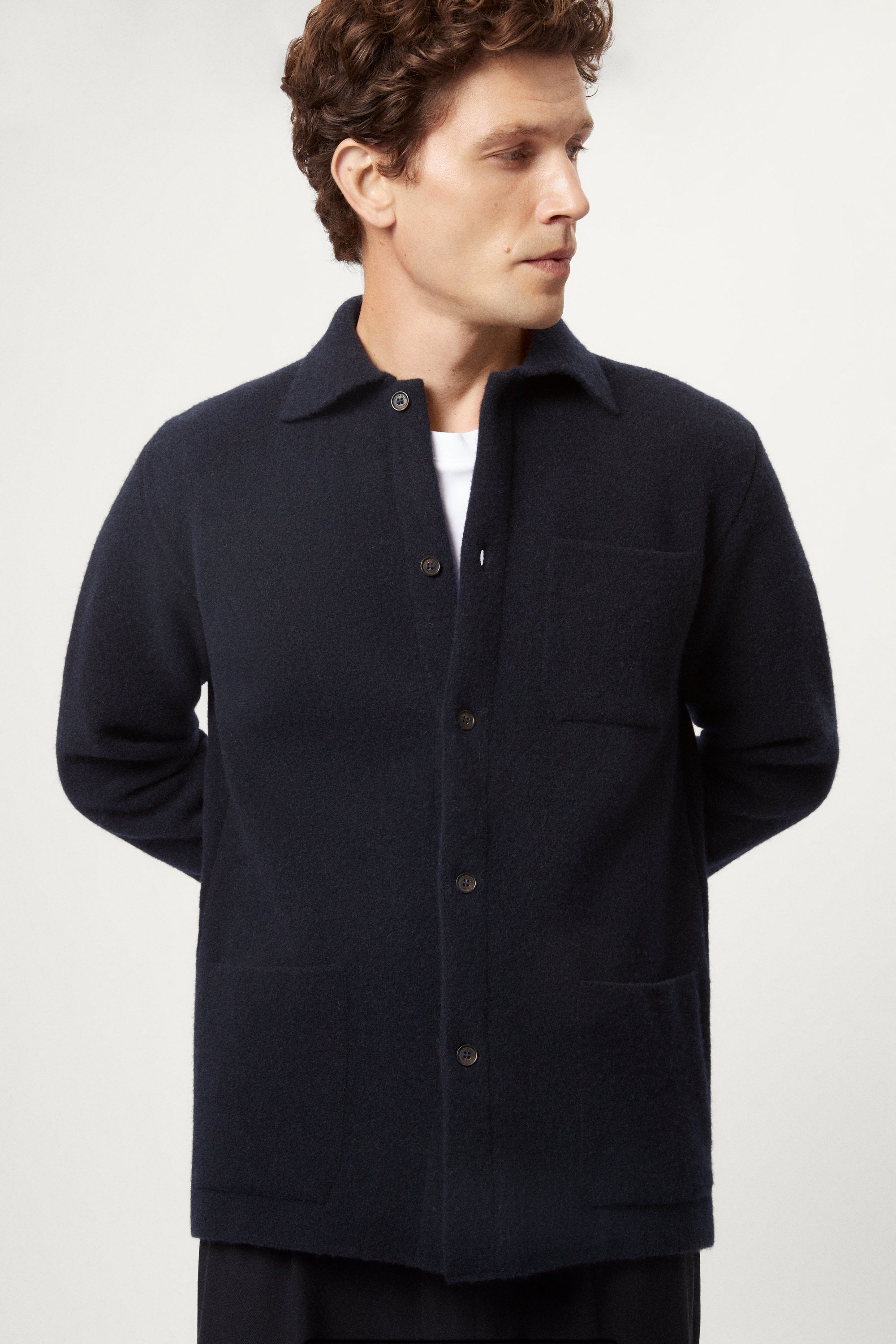 Man wearing a dark blue boiled wool jacket against a white background