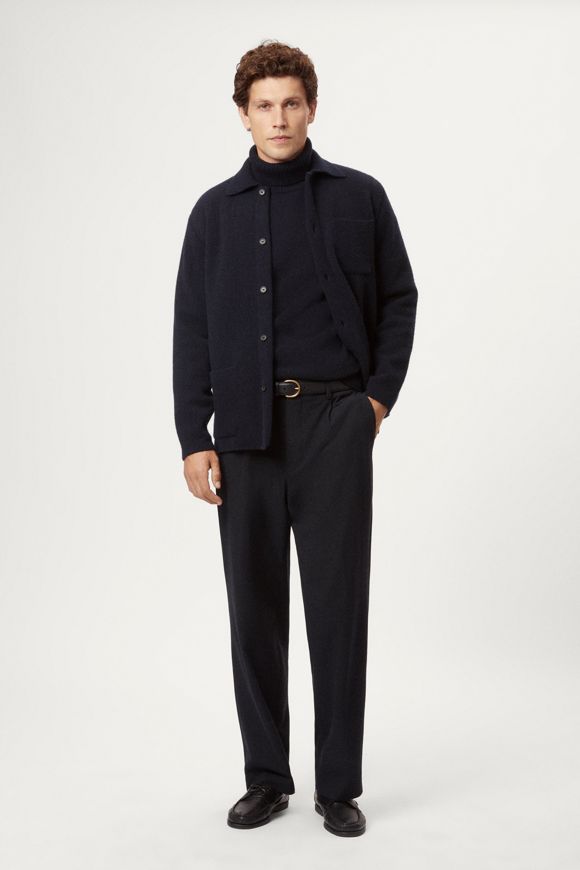 Man wearing a dark blue boiled wool jacket against a white background