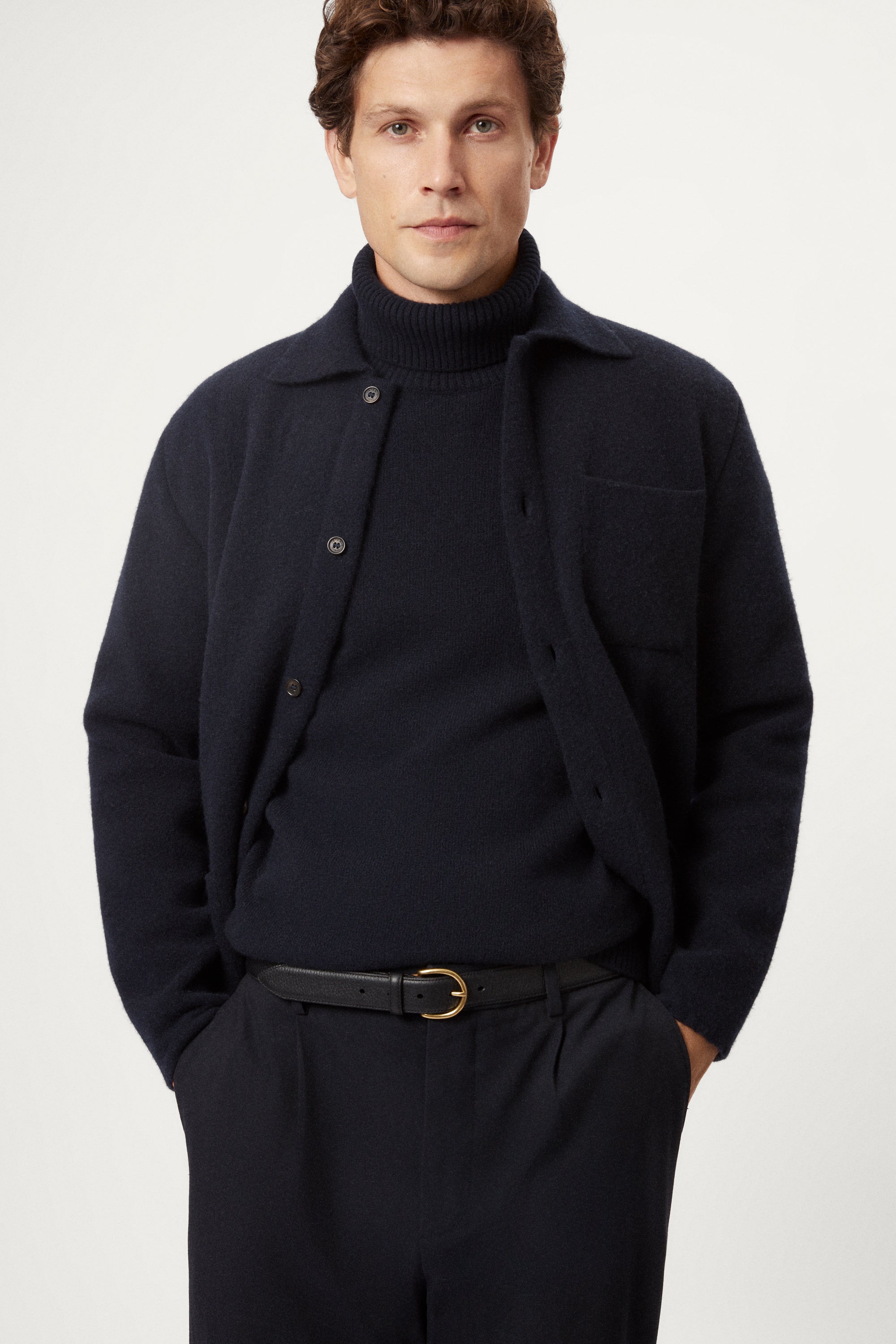 Man wearing a dark blue boiled wool jacket against a white background