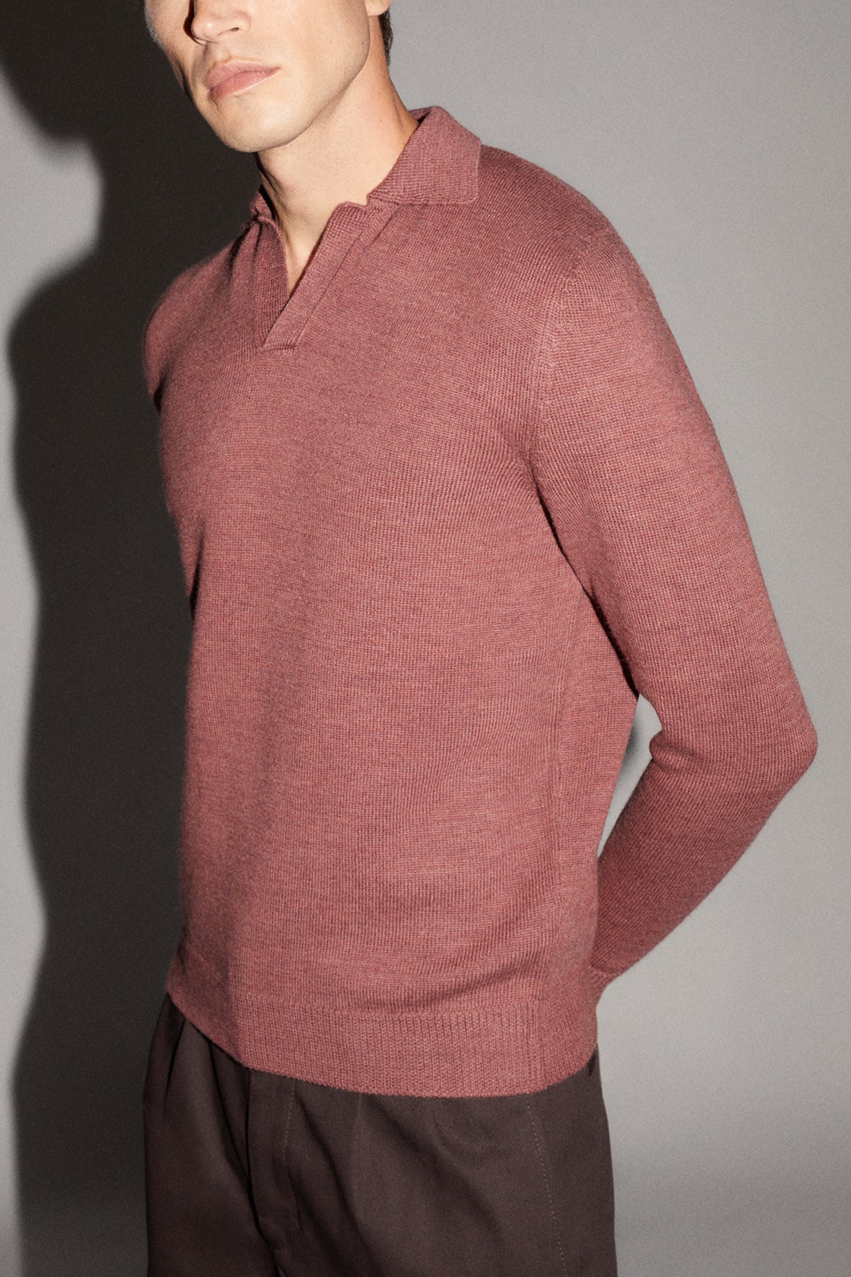 Person wearing a red sweater with a plain background