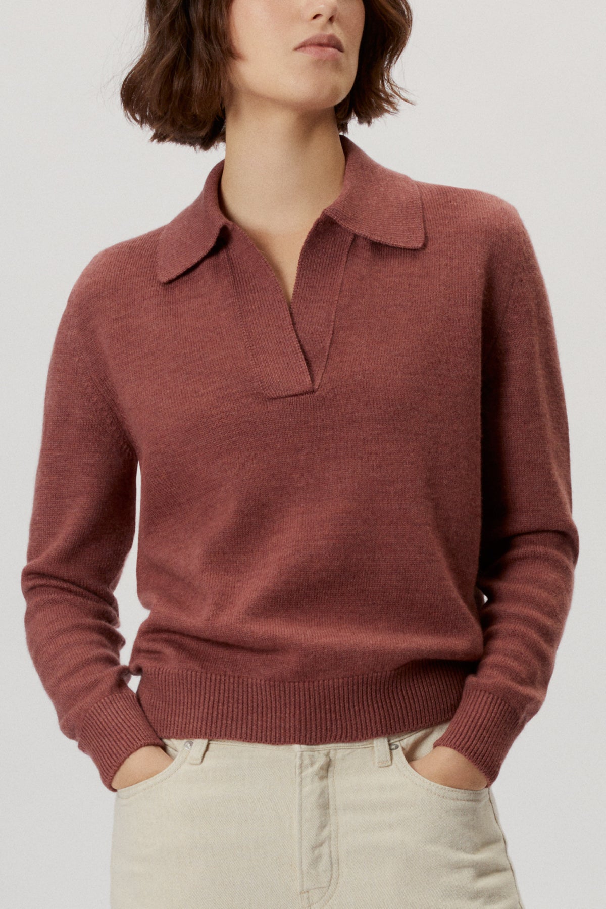 Person wearing a natural dye polo madder red on a white background