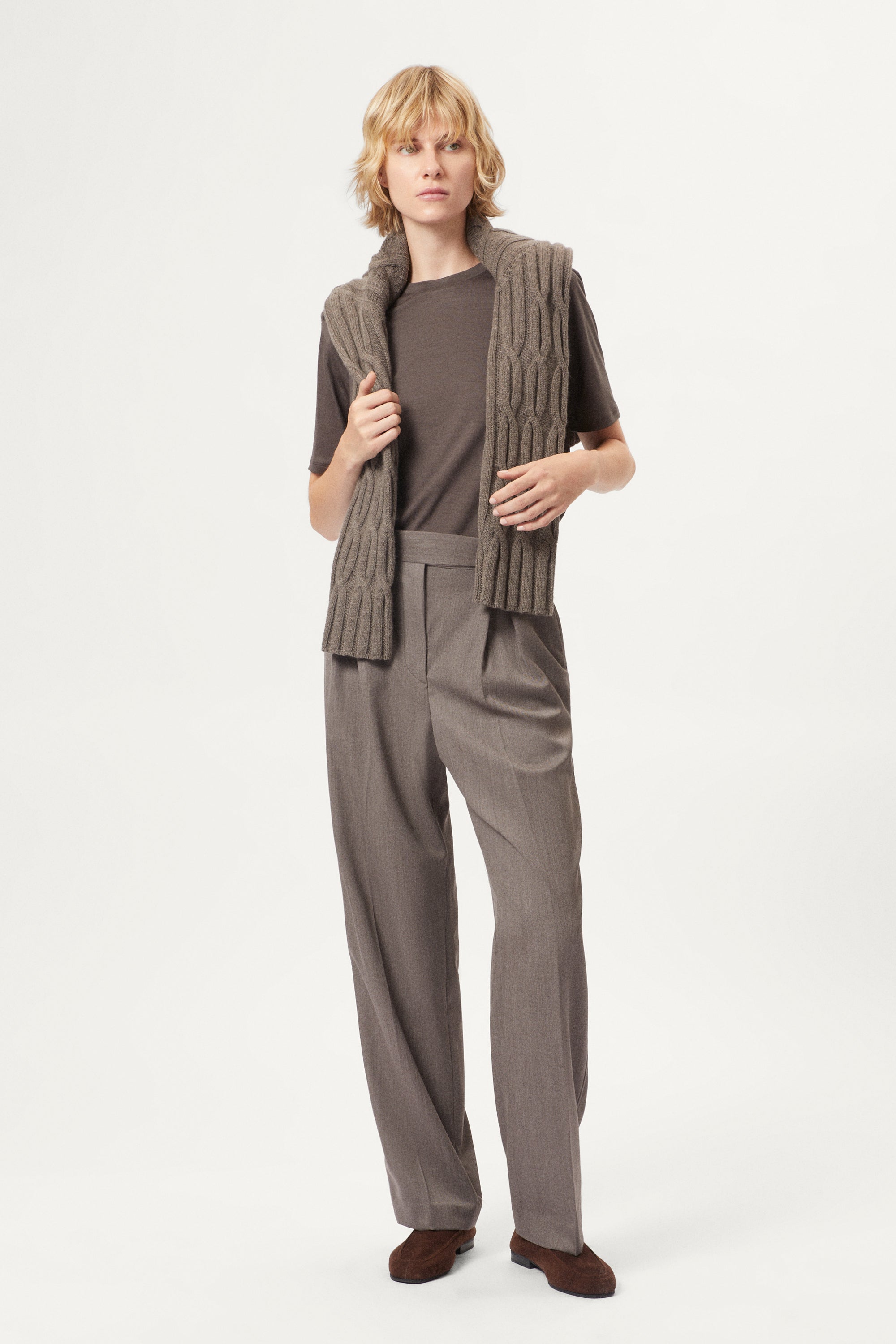 Person wearing a brown active wool t-shirt and pants on a white background