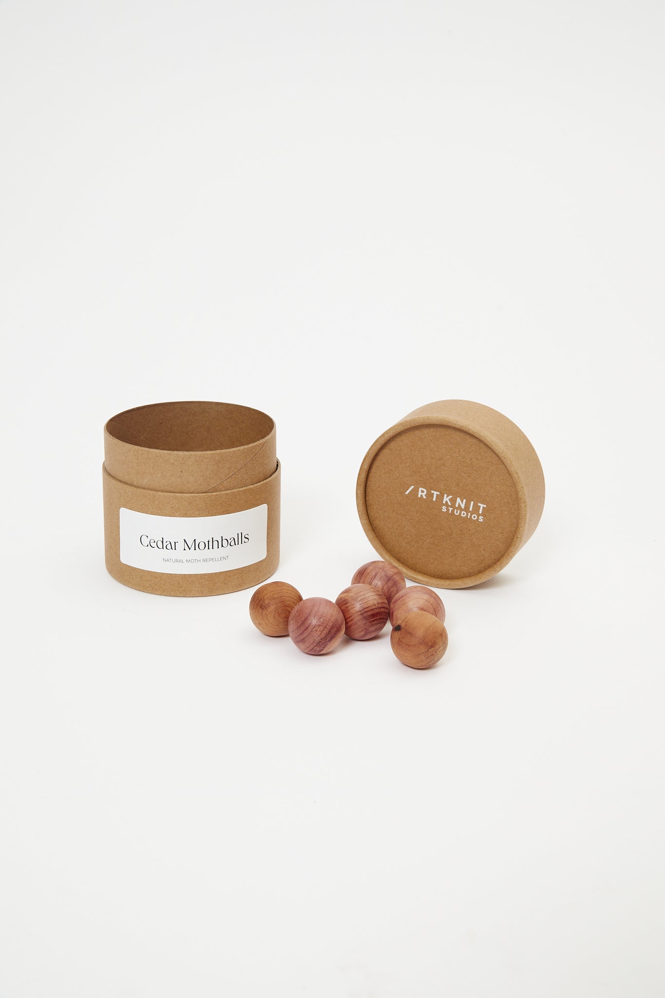 Brown container with cedar mothballs on a white background