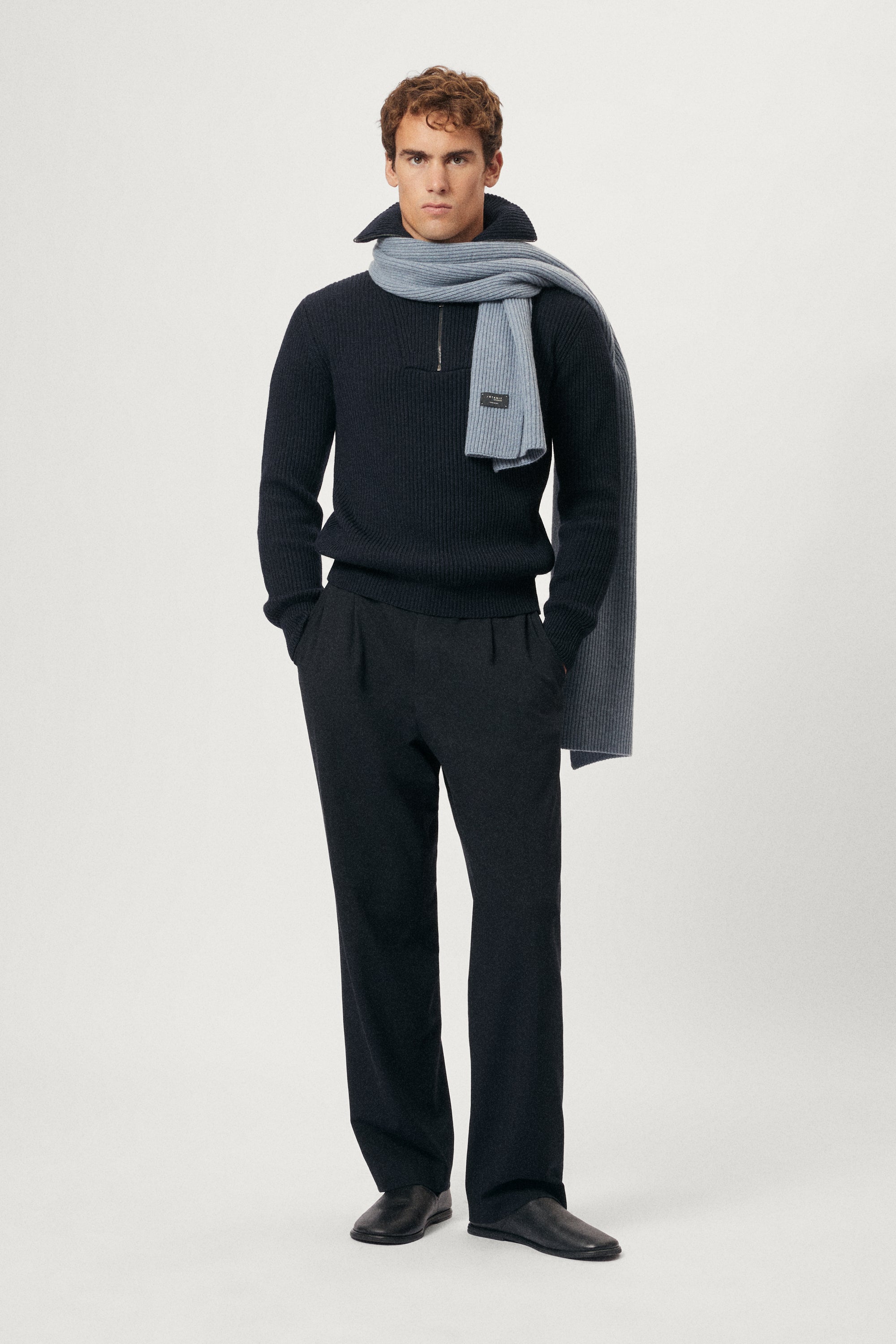 Man wearing a ash blue woolen scarf over his shoulders against a plain background