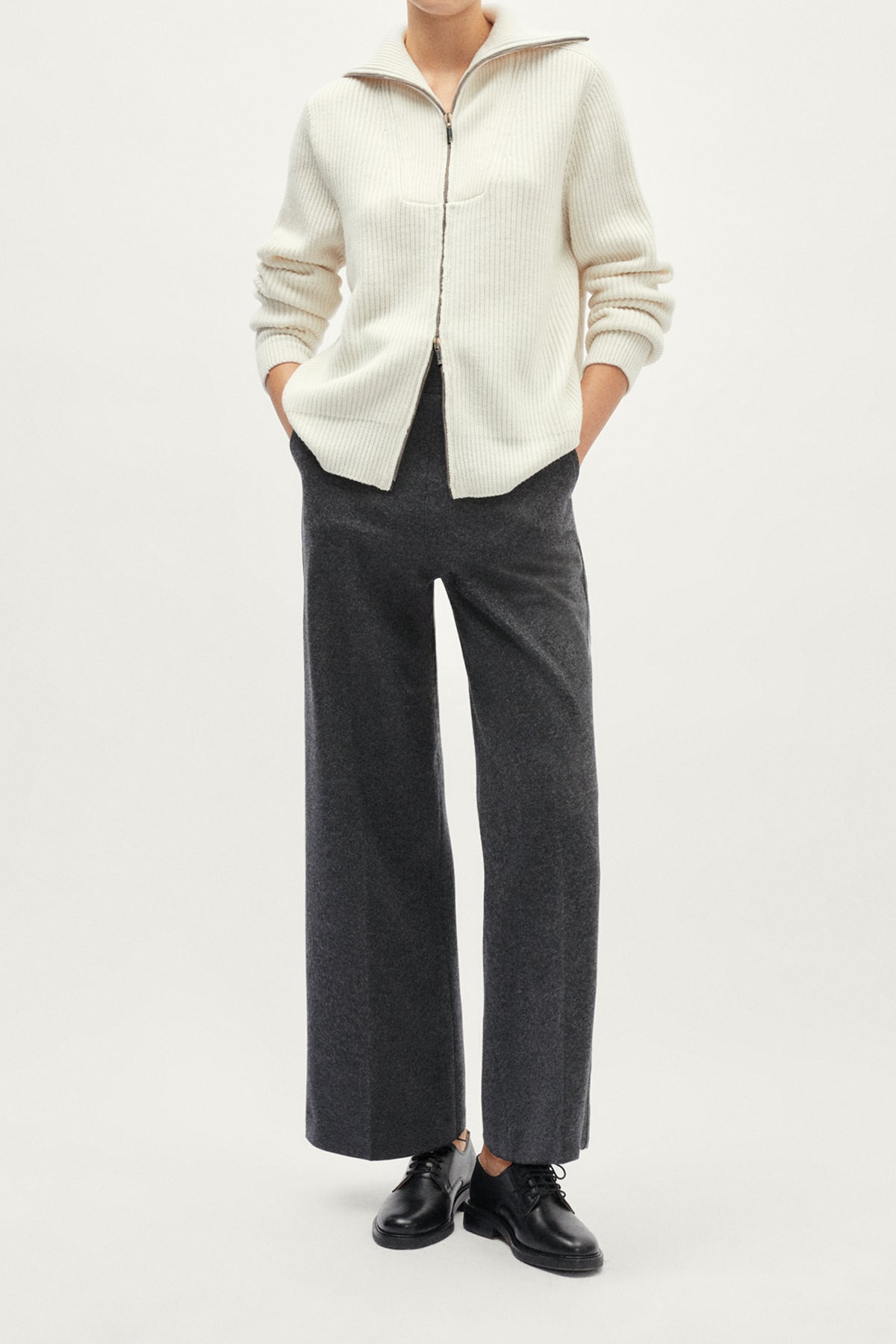 White ribbed sweater with a zipper on a light gray background