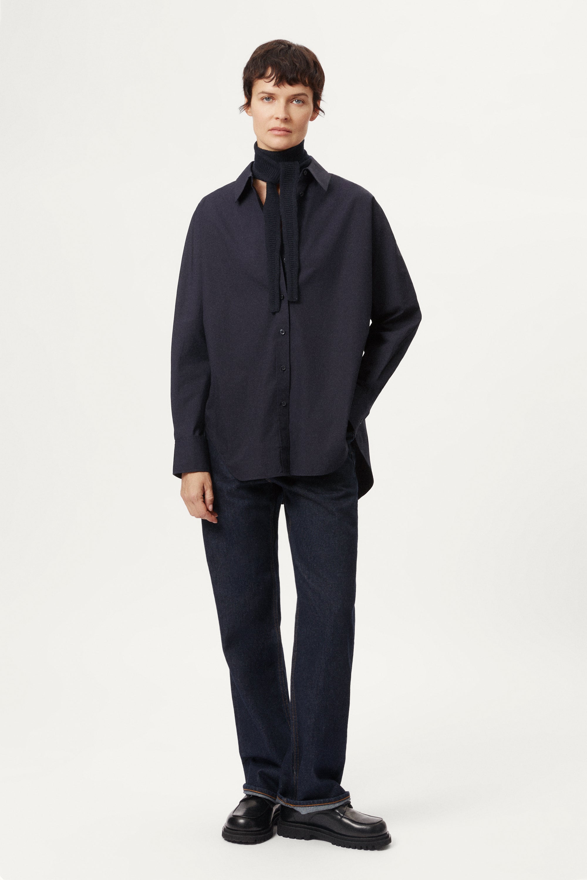 Person wearing a blue navy Woolen Mini Scarf over a blue shirt