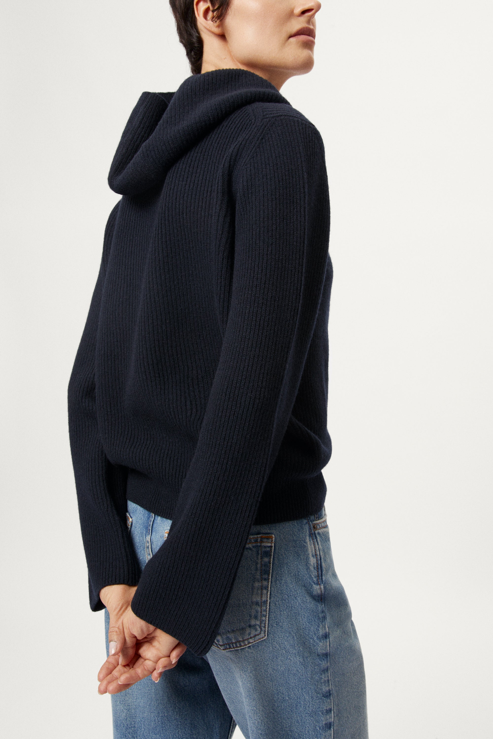 Person wearing a blue navy Woolen Ribbed Hoodie and blue jeans on a white background