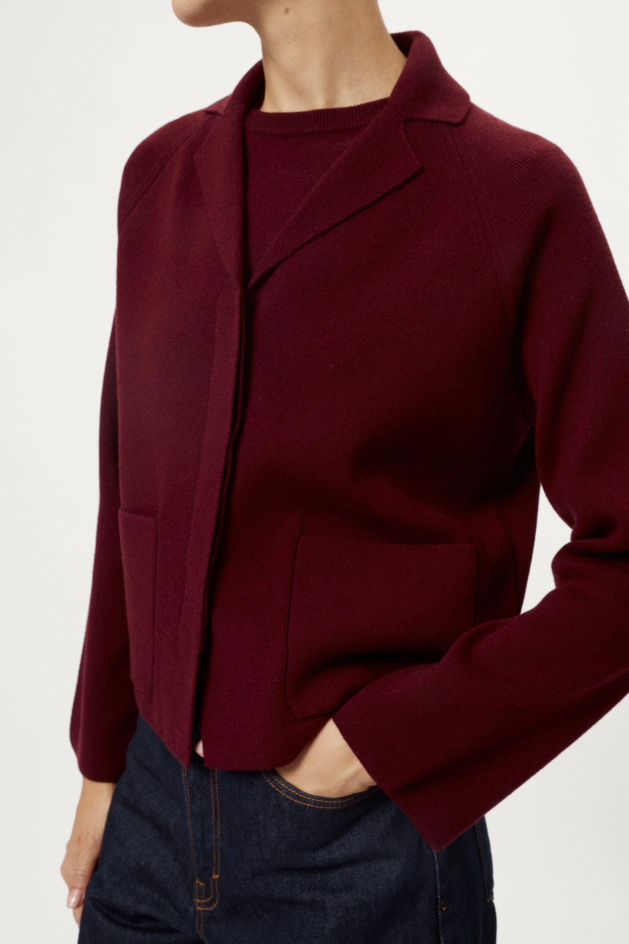 Woman wearing a burgundy jacket on a white background