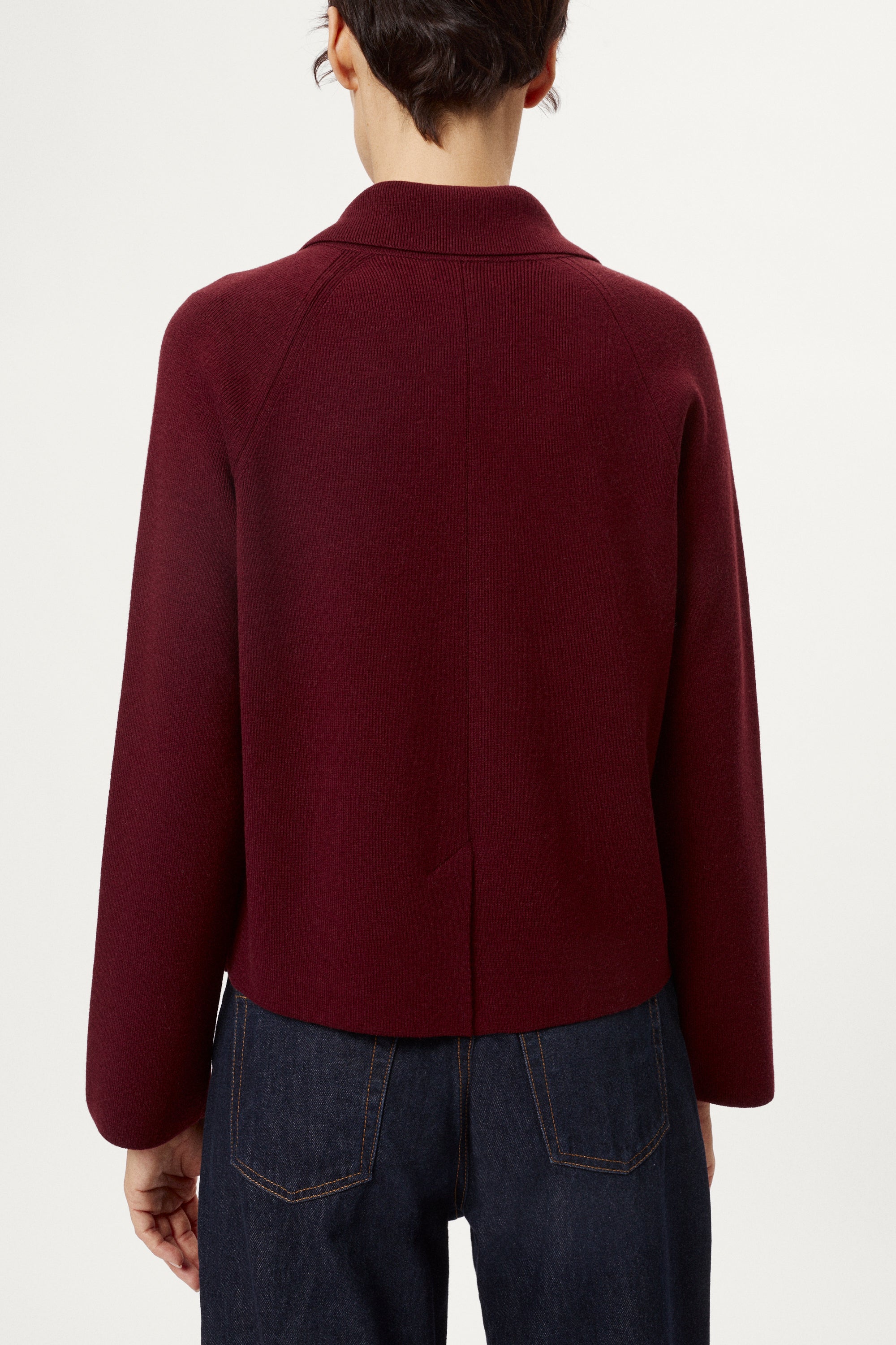 Woman wearing a burgundy jacket on a white background