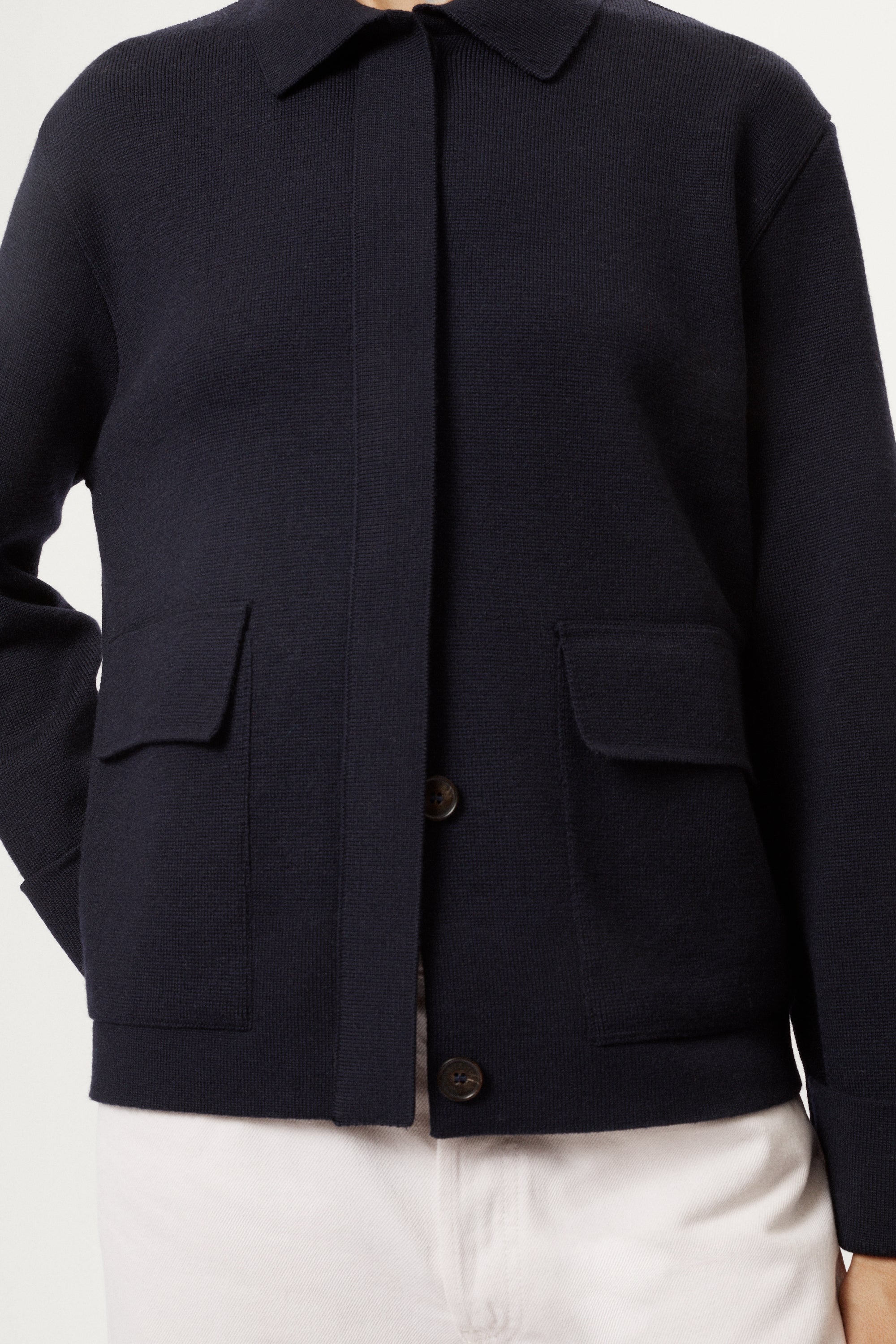 Navy blue jacket with button details on a white background