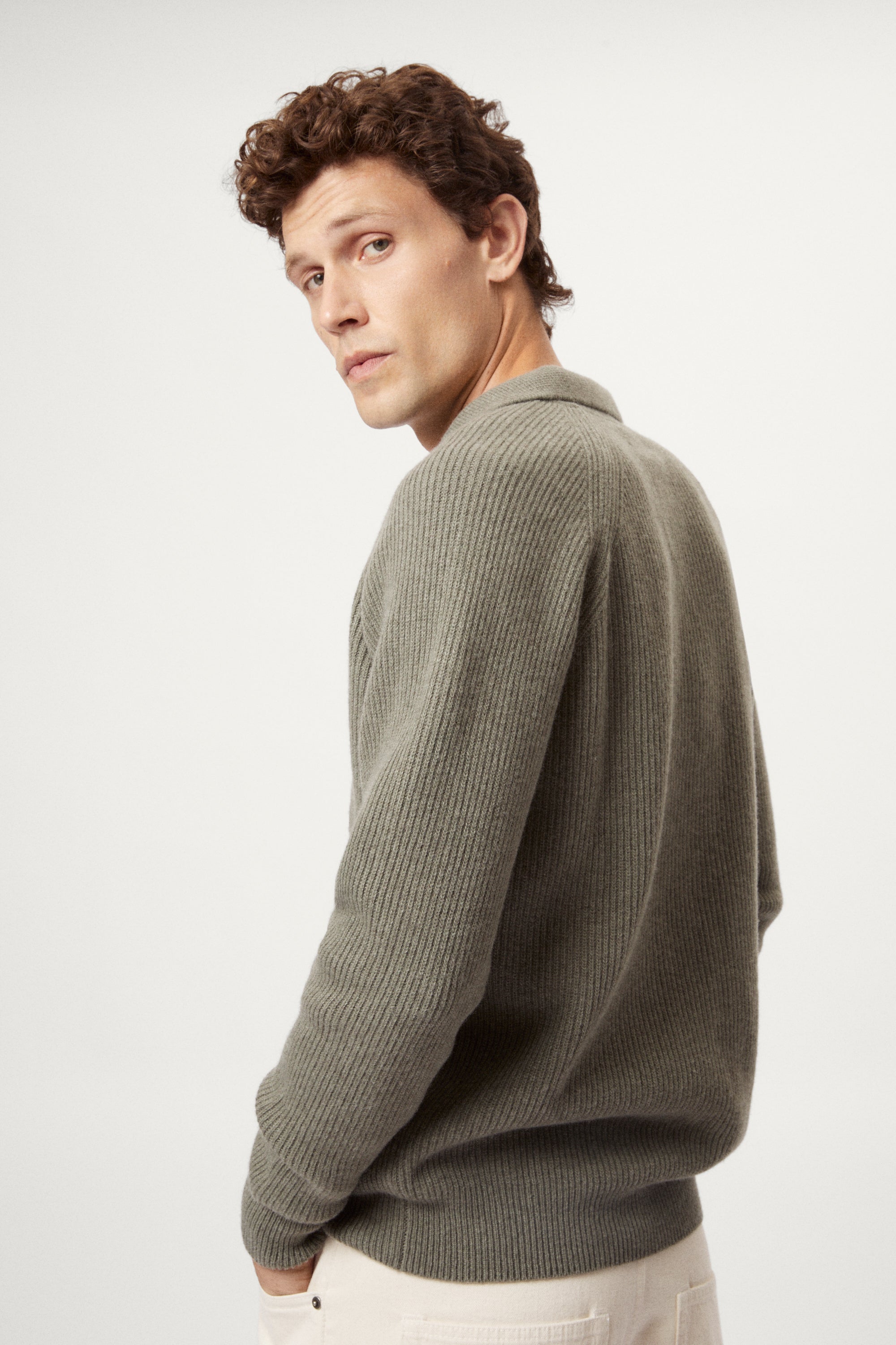 Man wearing a green sweater against a white background