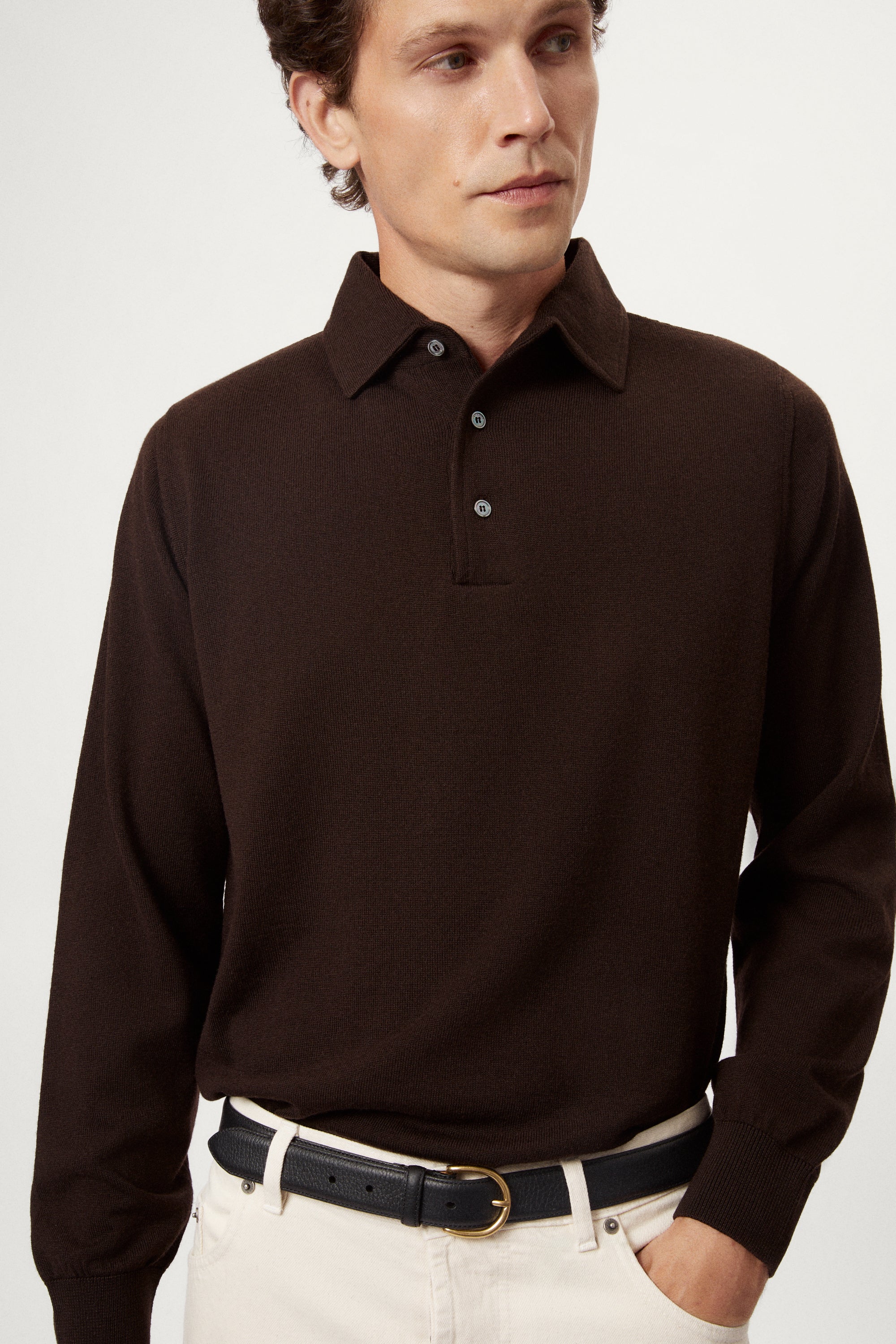 Man wearing a brown long-sleeve polo shirt on a white background