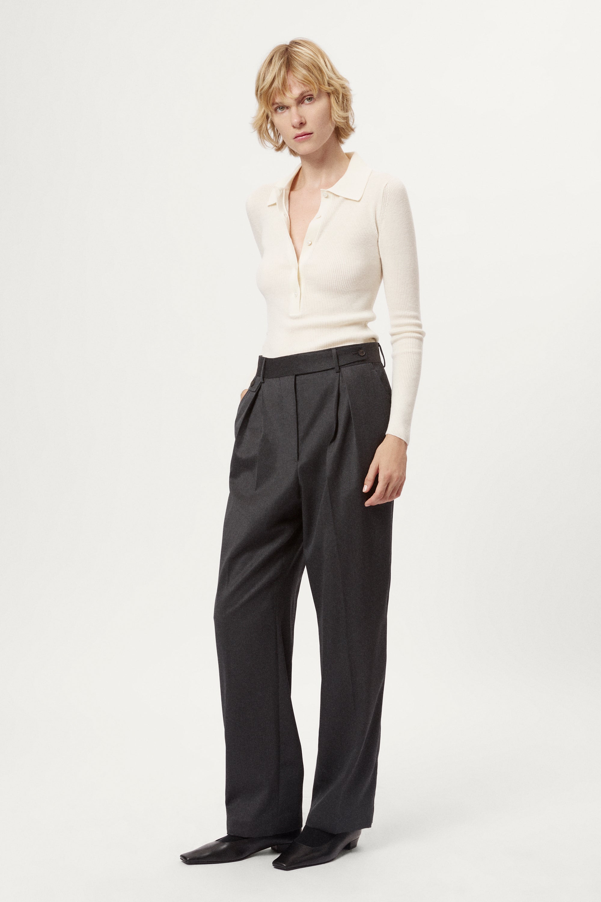 Dark gray pleated pants with a white background