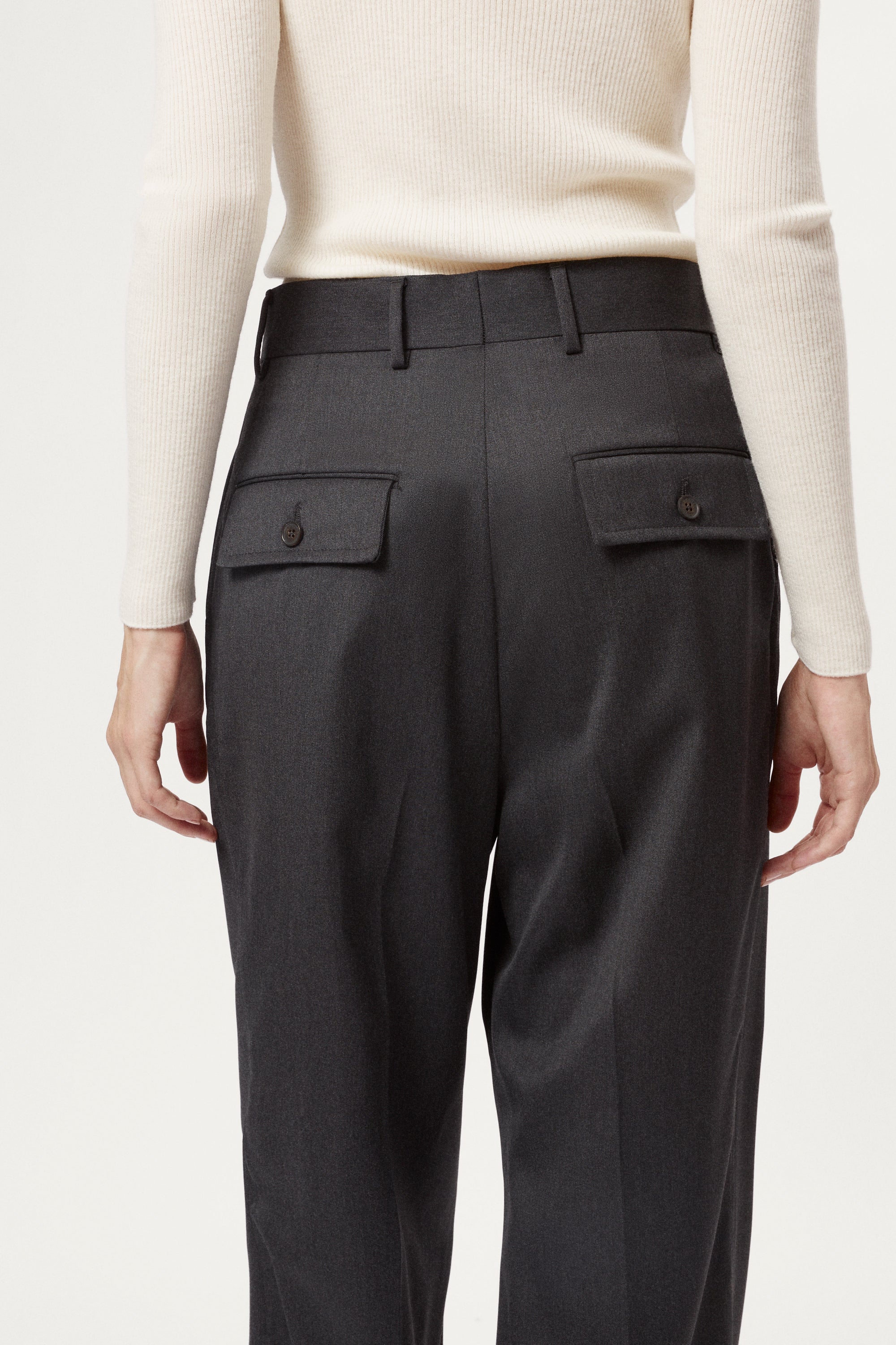grey pants with two front pockets worn by a woman against a white background