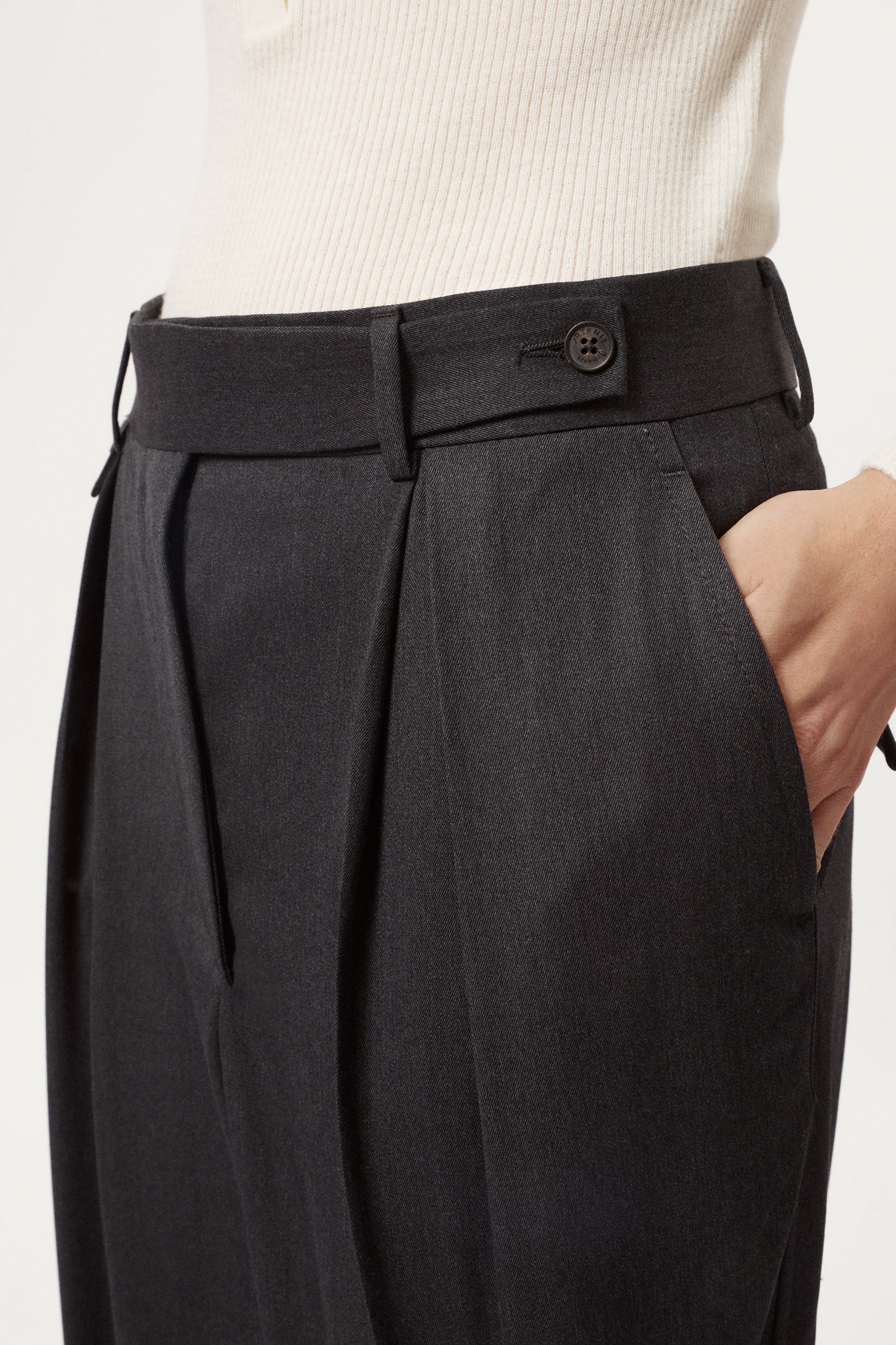 Dark gray pleated pants with a white background