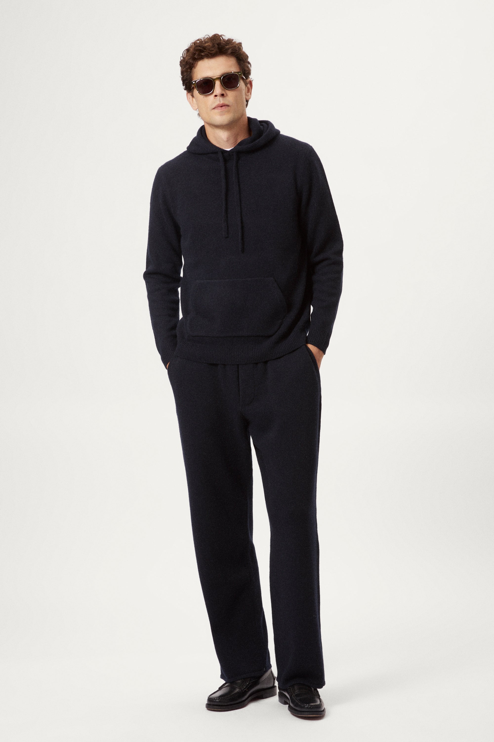 Man wearing a blue navy woolen hoodie and pants on a white background