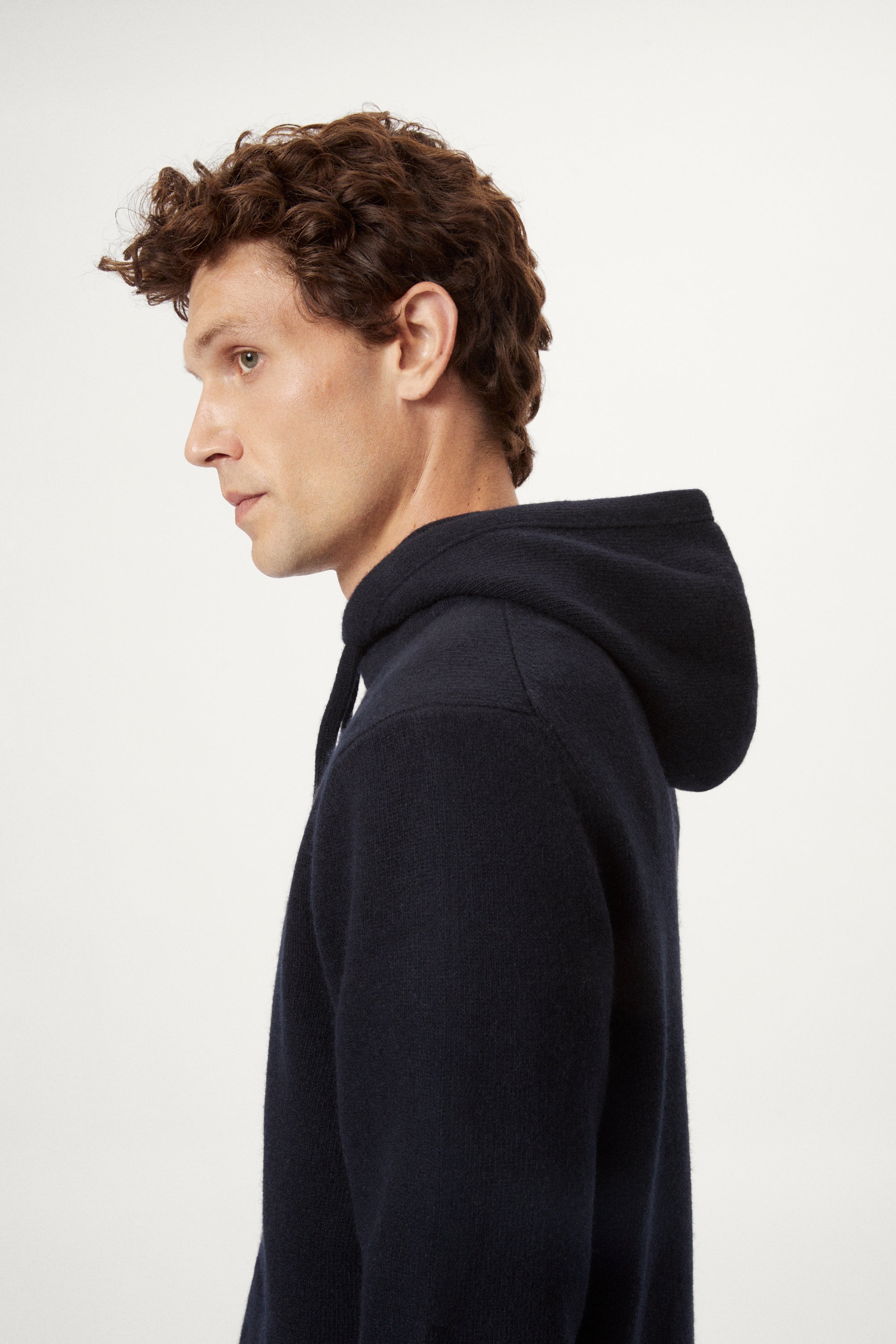 Man wearing a blue navy woolen hoodie and pants on a white background