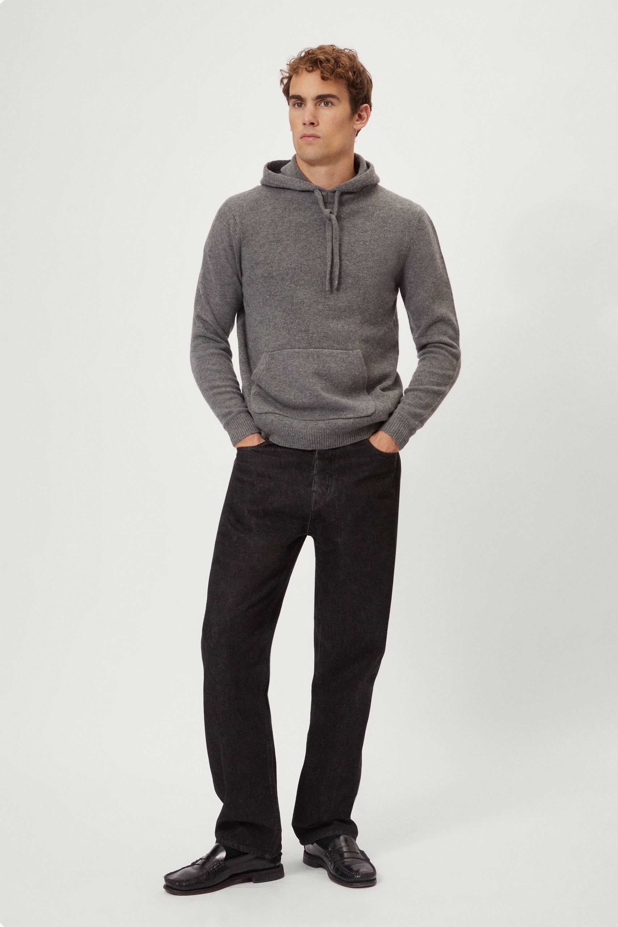 Man wearing a light gray woolen  hoodie on a white background