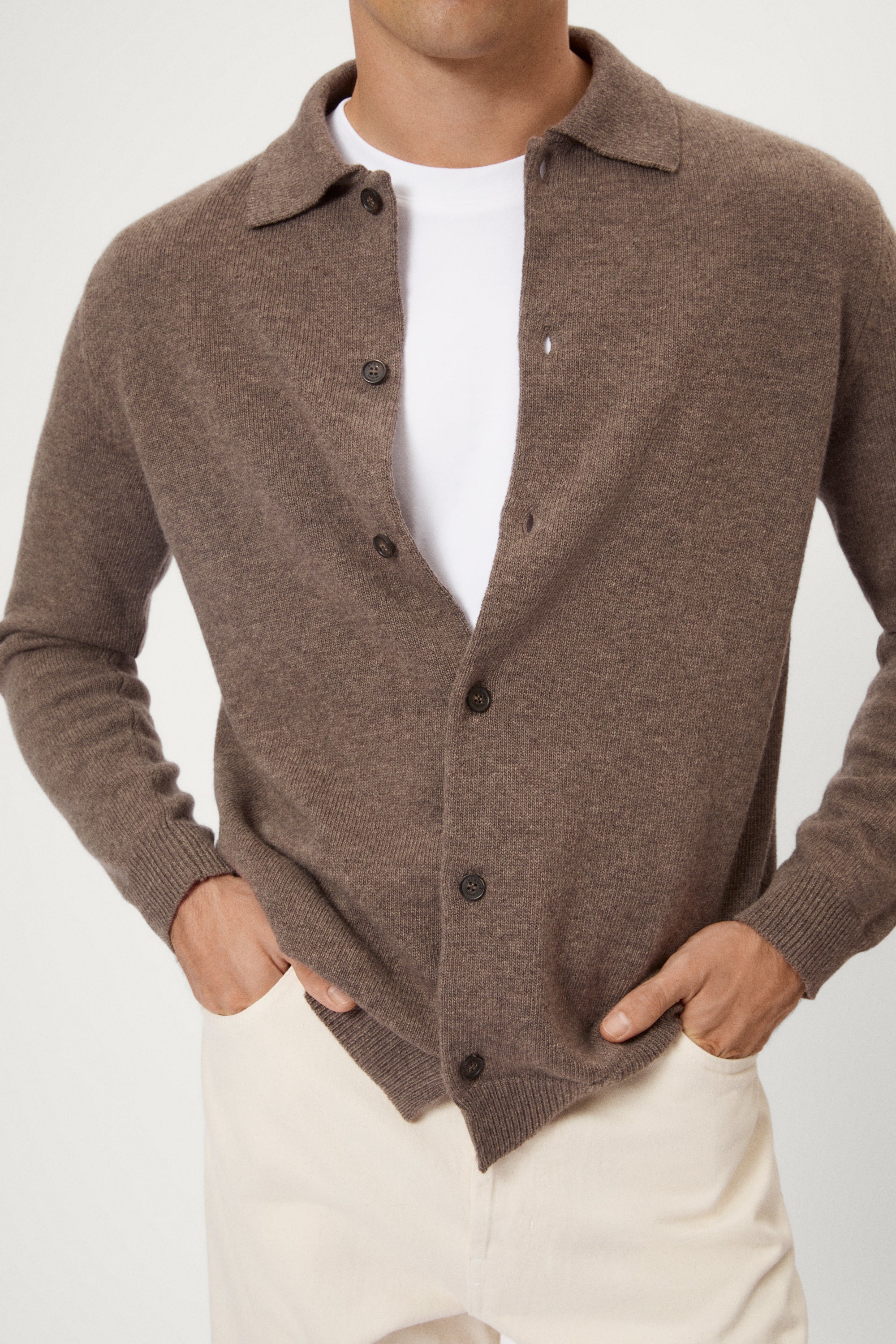 Man wearing a brown woolen polo shirt on a white background