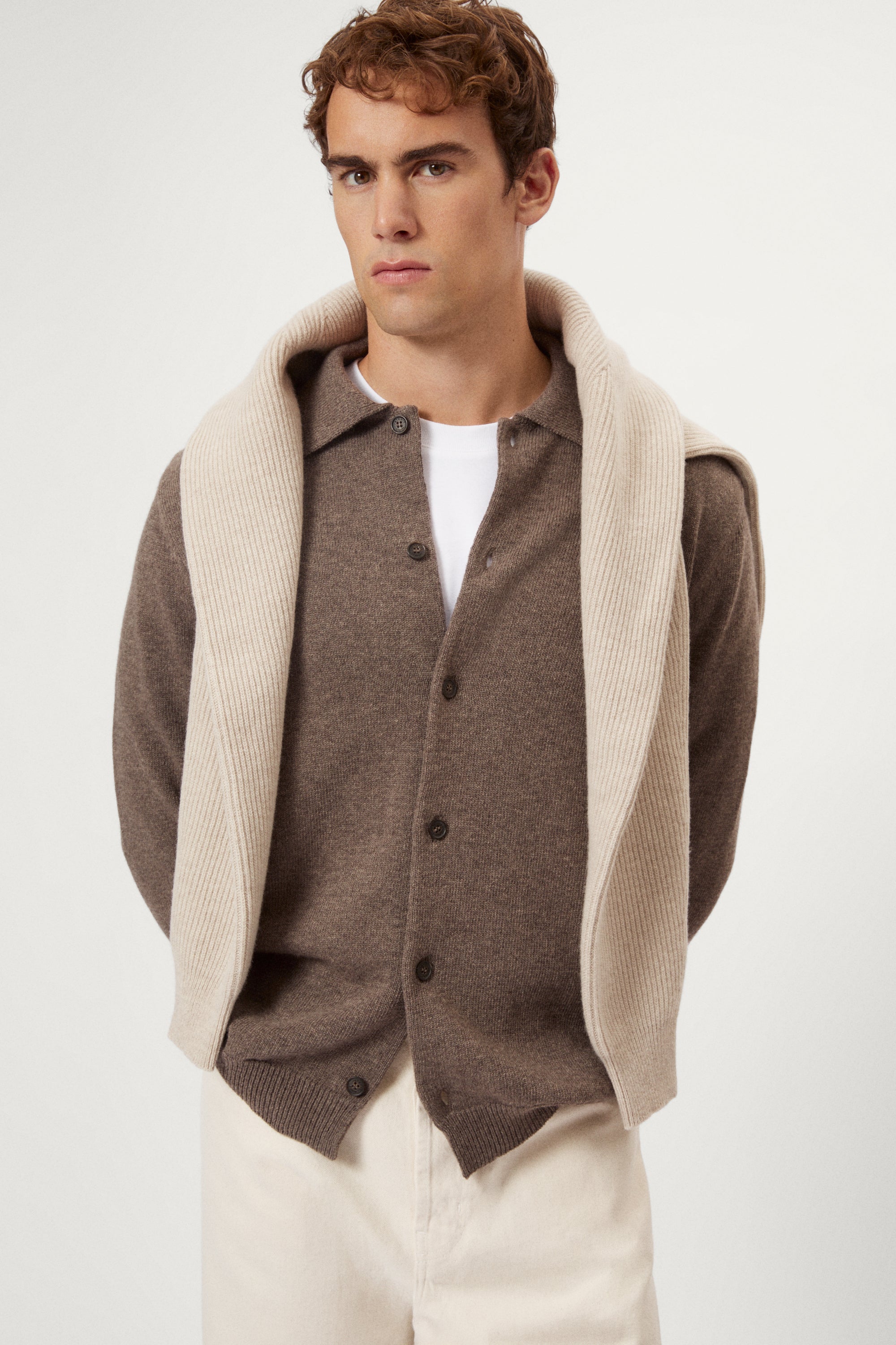 Man wearing a brown woolen polo shirt on a white background