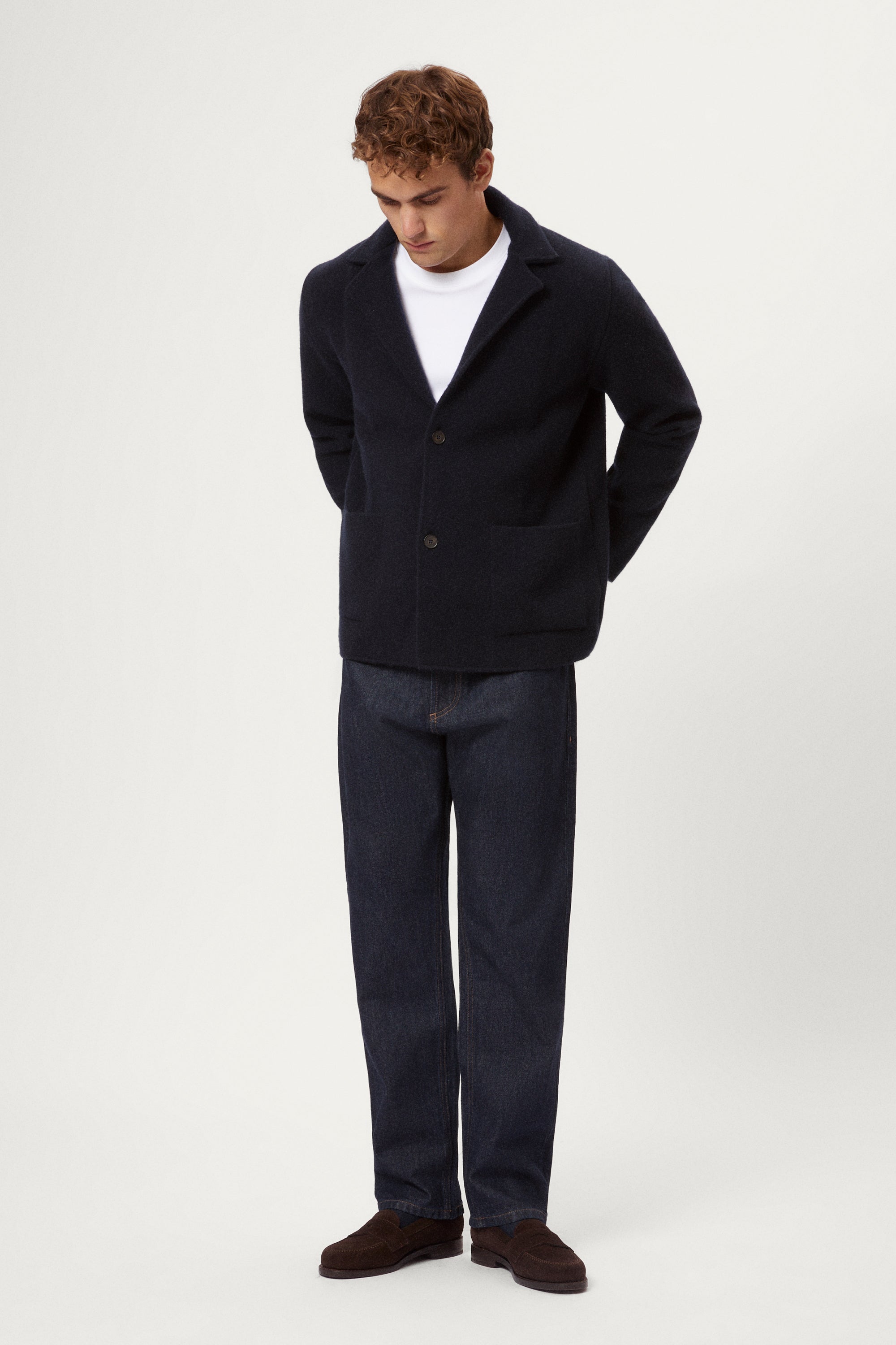 Man wearing a blue Boiled Wool Blazer, white shirt, and dark jeans on a white background