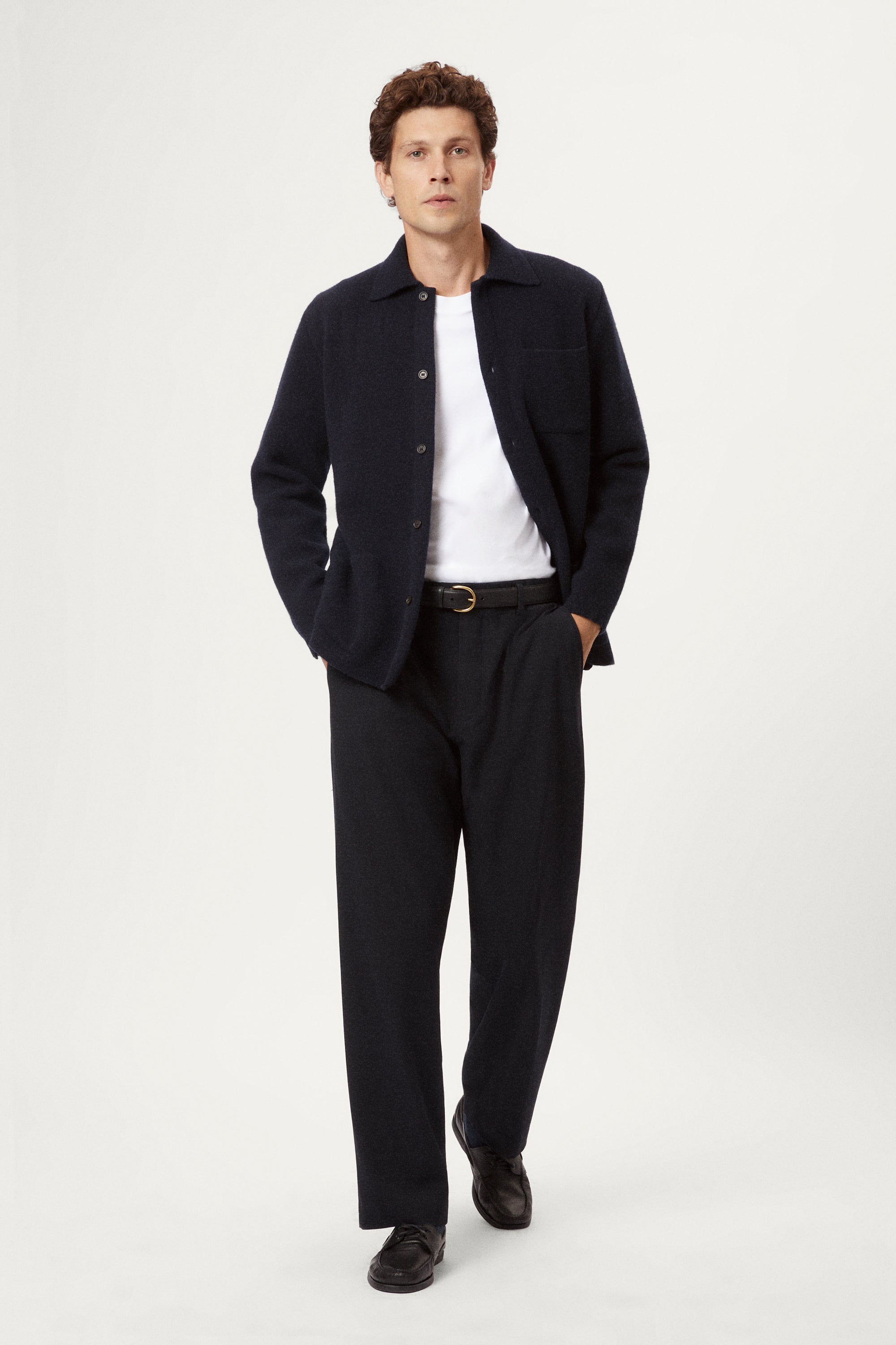 Man wearing a dark blue boiled wool jacket against a white background