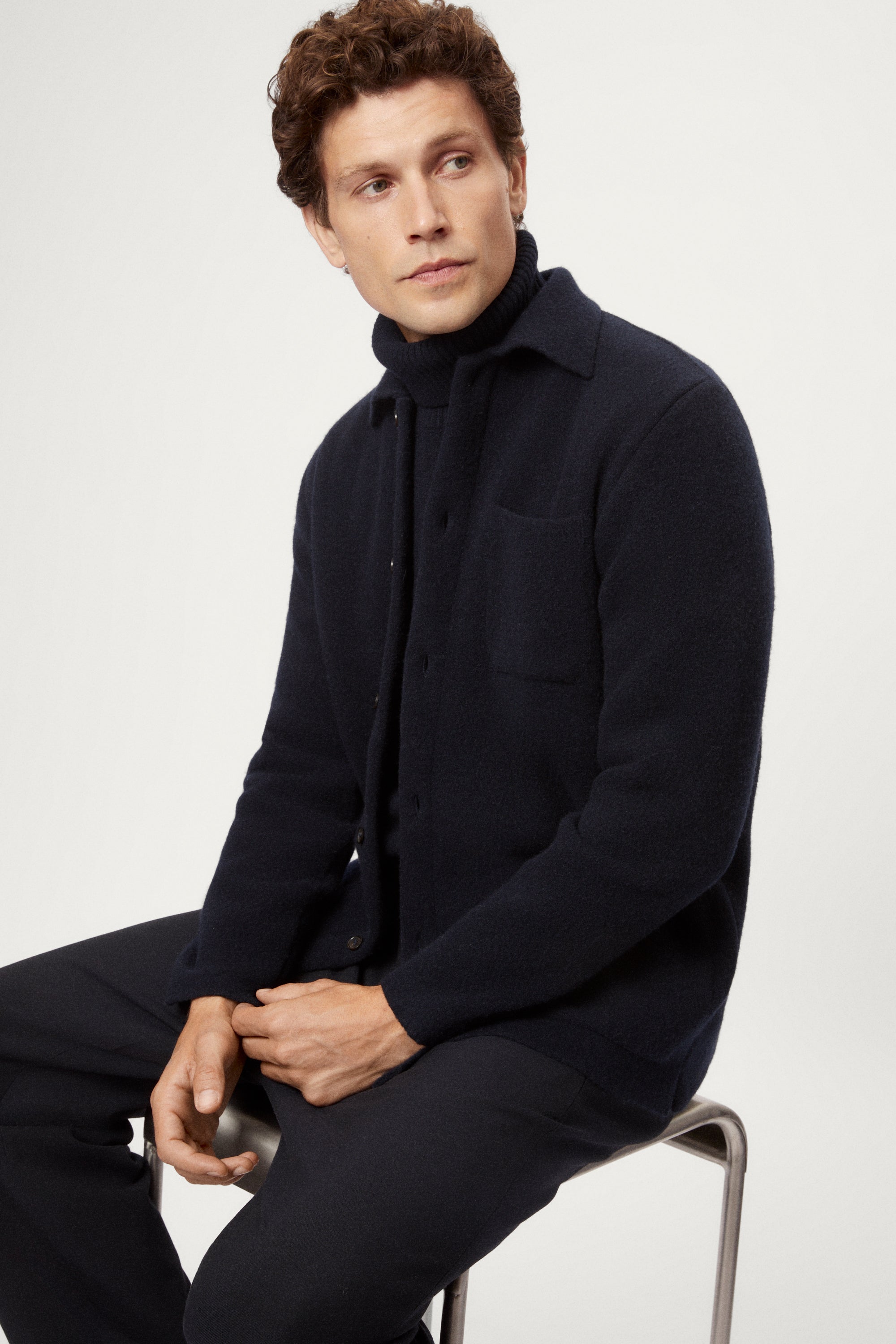 Man wearing a dark blue boiled wool jacket against a white background