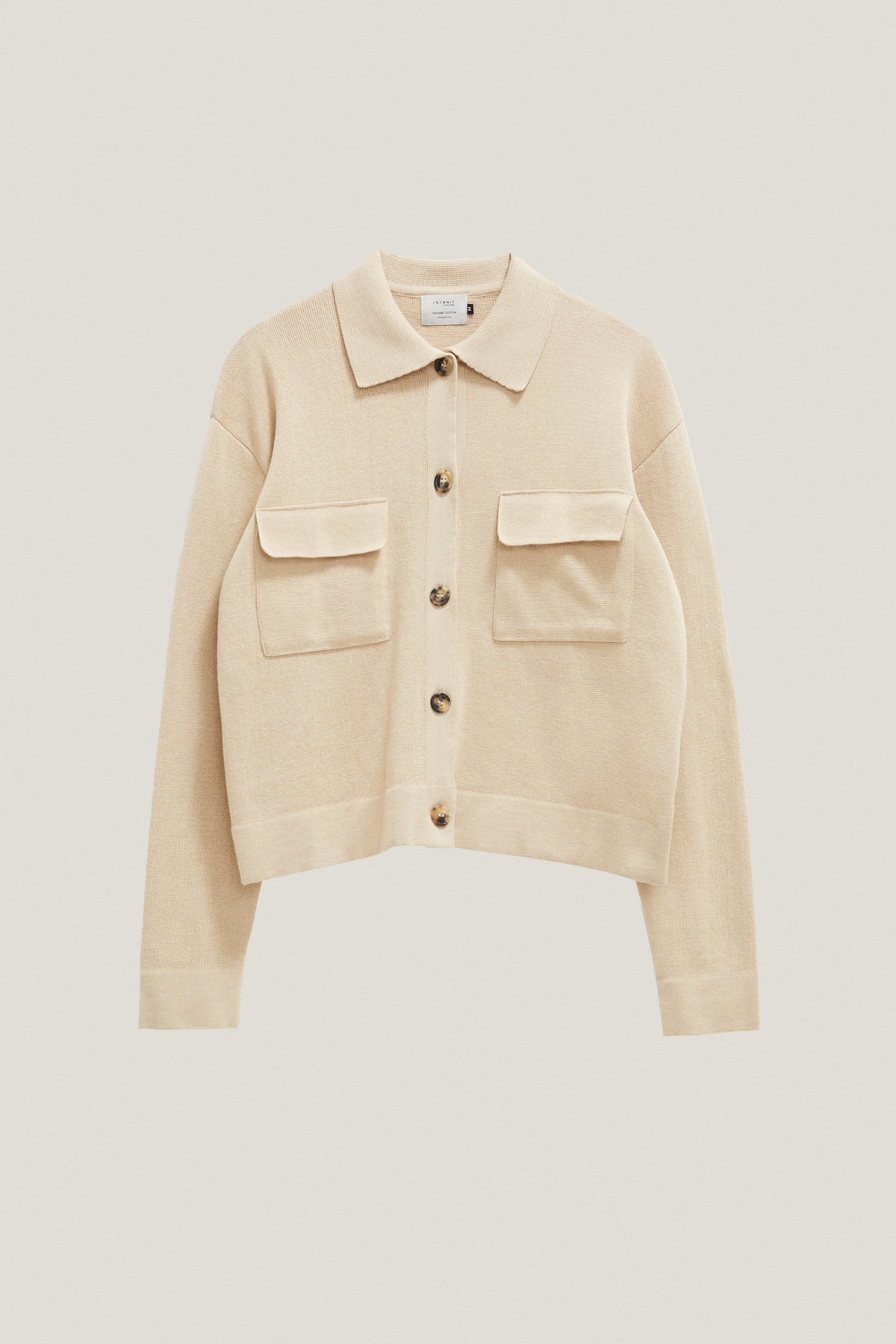 Beige jacket with button details on a light beige background